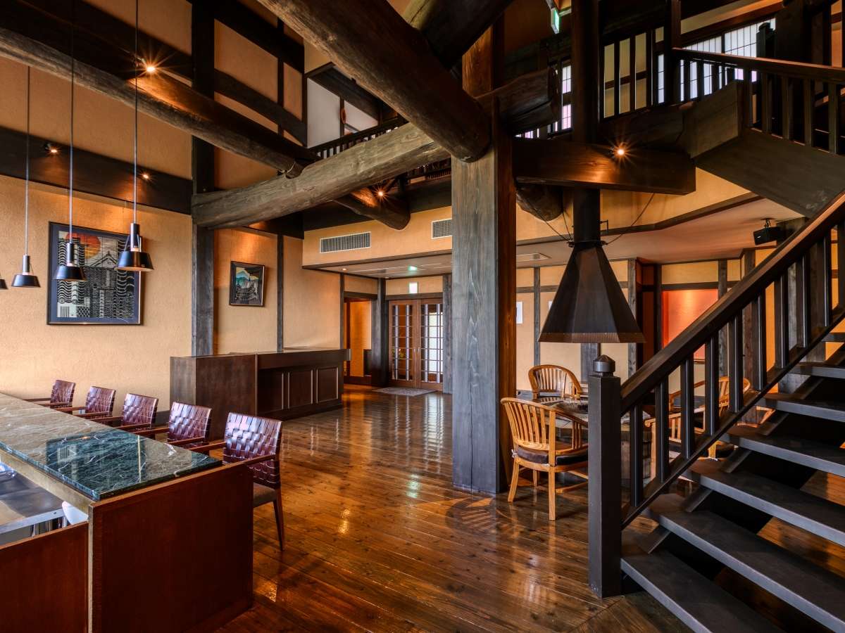 Lobby and lounge interior at Tosyoan with heavy wooden beams, polished floors and an open staircase