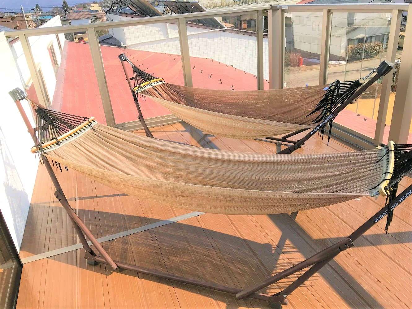 Rooftop terrace with two hammocks and wooden decking at K's House Fuji View