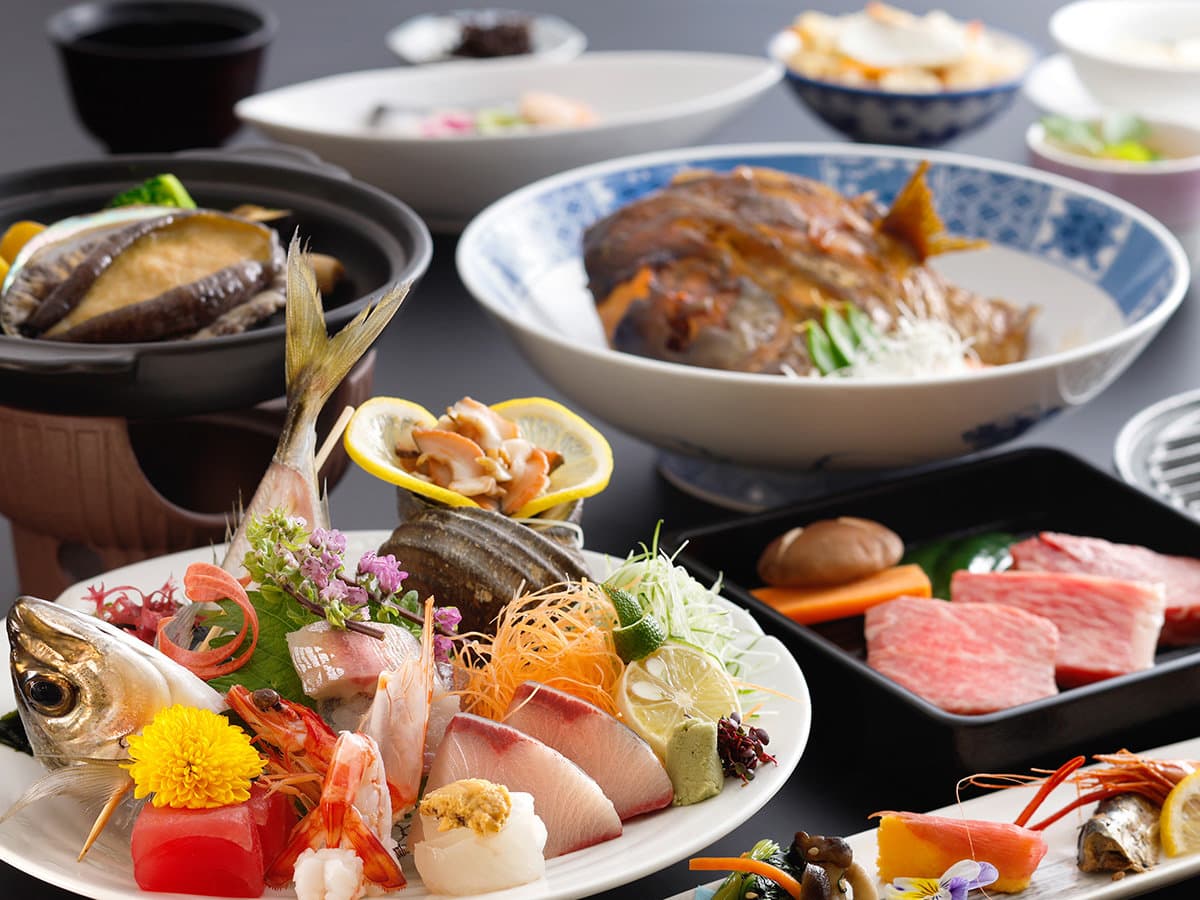 Multi-course kaiseki dinner spread with sashimi, simmered fish and Seto Inland Sea seafood at Dogo Grand Hotel