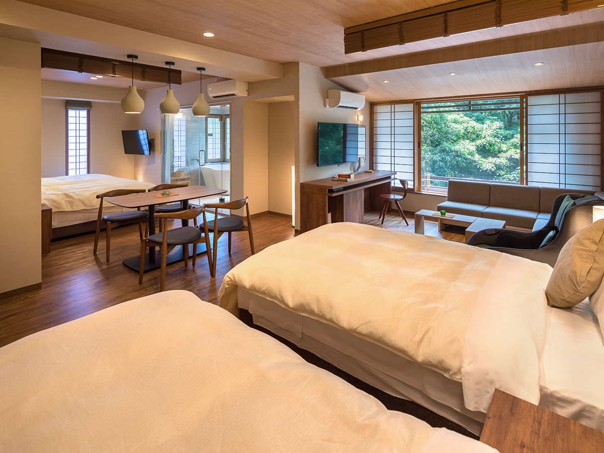 Large guest room at Hotel Miyajima Villa with twin beds, lounge sofa and in-room bath