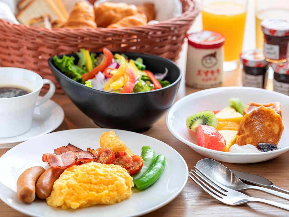Morning breakfast spread with salad, eggs, sausages, fresh bread and fruit at Hotel Miyajima Villa