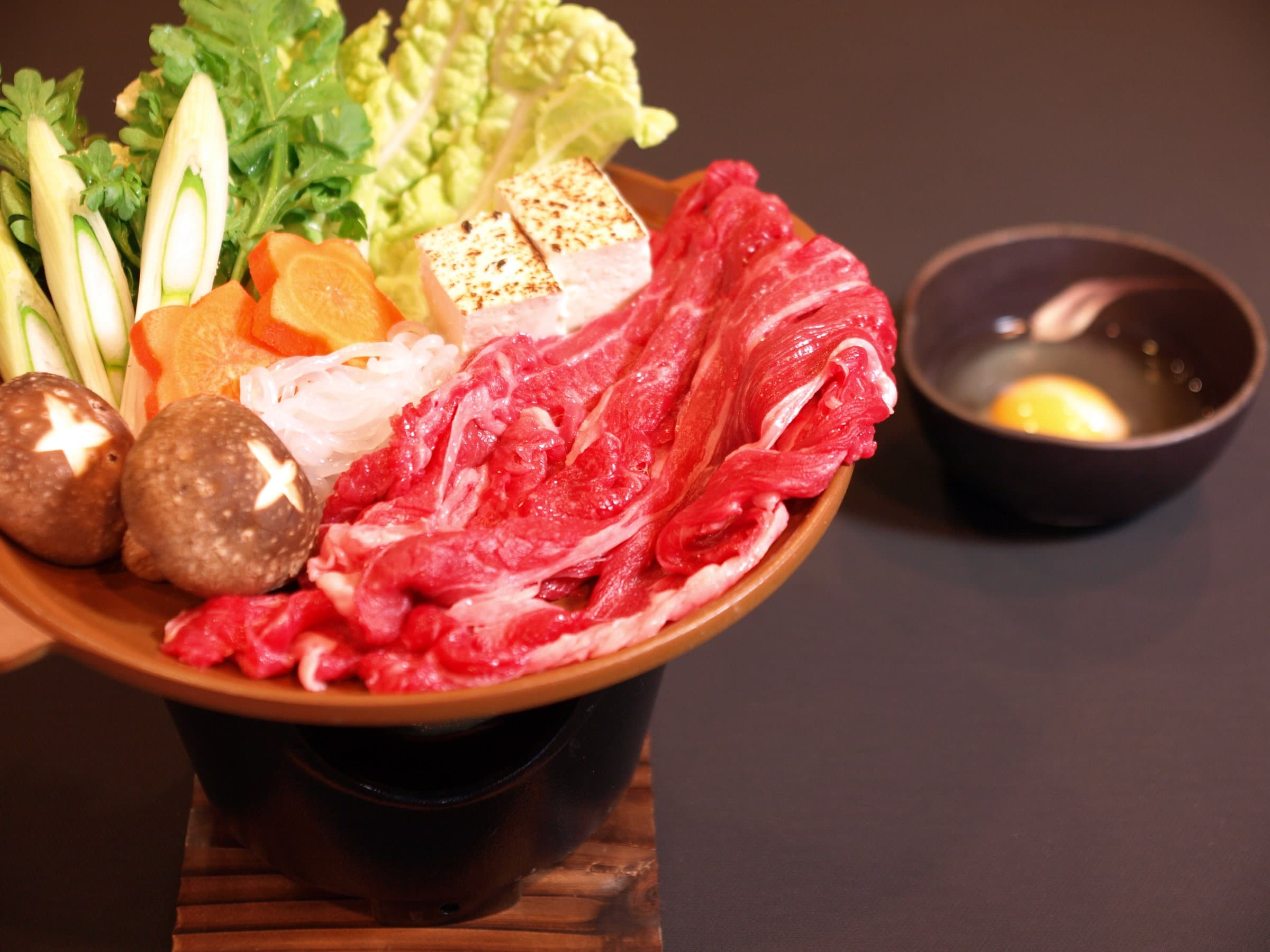 Sliced beef sukiyaki hot pot set with fresh vegetables, tofu and a beaten egg dip served at Shirouma-so in Hakuba