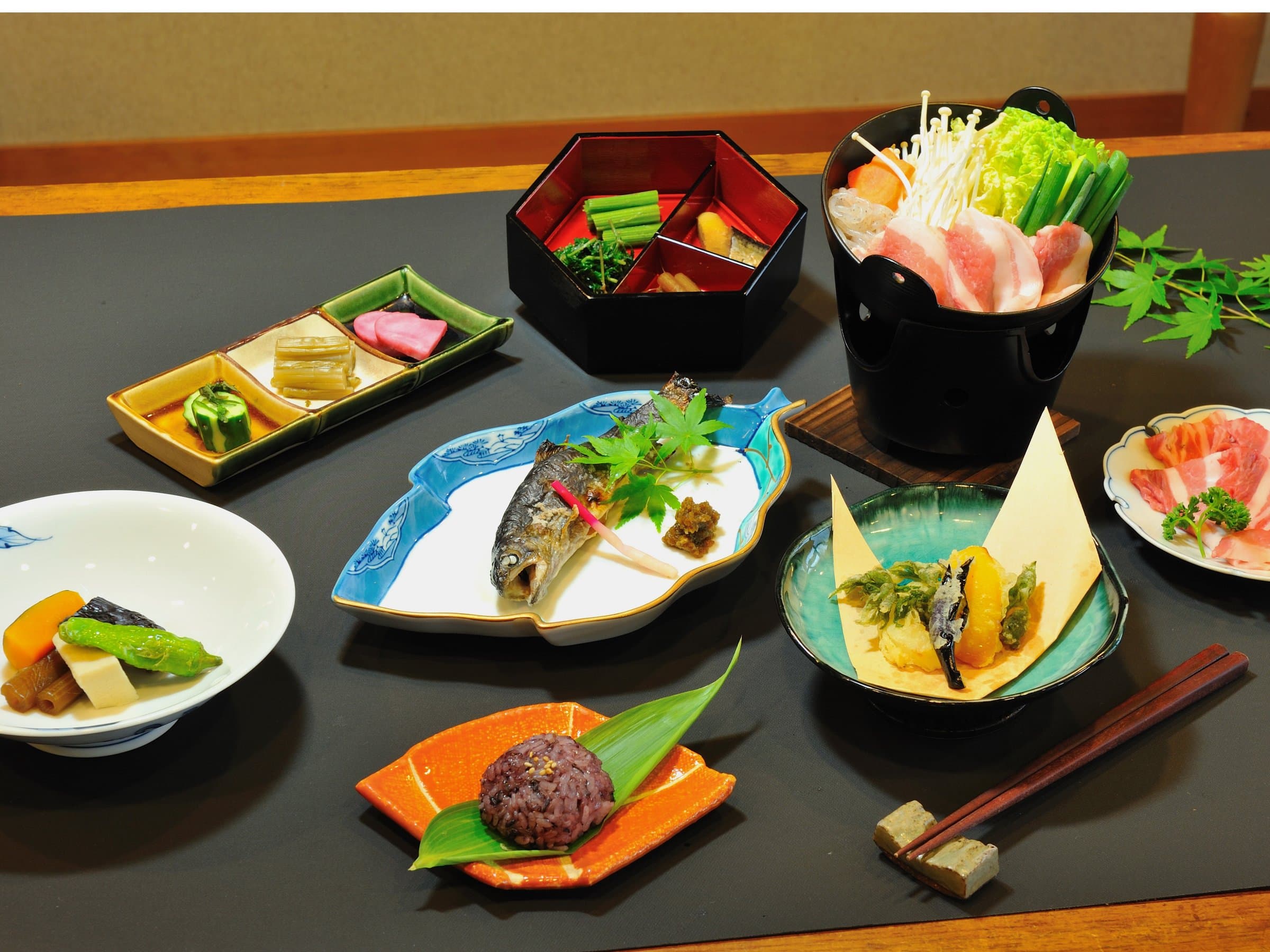 Multi-course kaiseki dinner spread with grilled fish, simmered dishes and an individual hot pot served at Shirouma-so