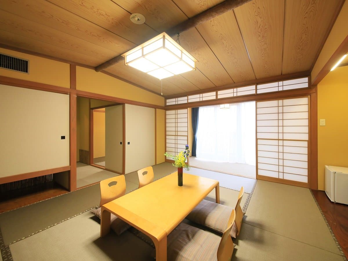 Traditional tatami guest room at Atami Fuga with shoji screens, a low wooden table and floor cushions
