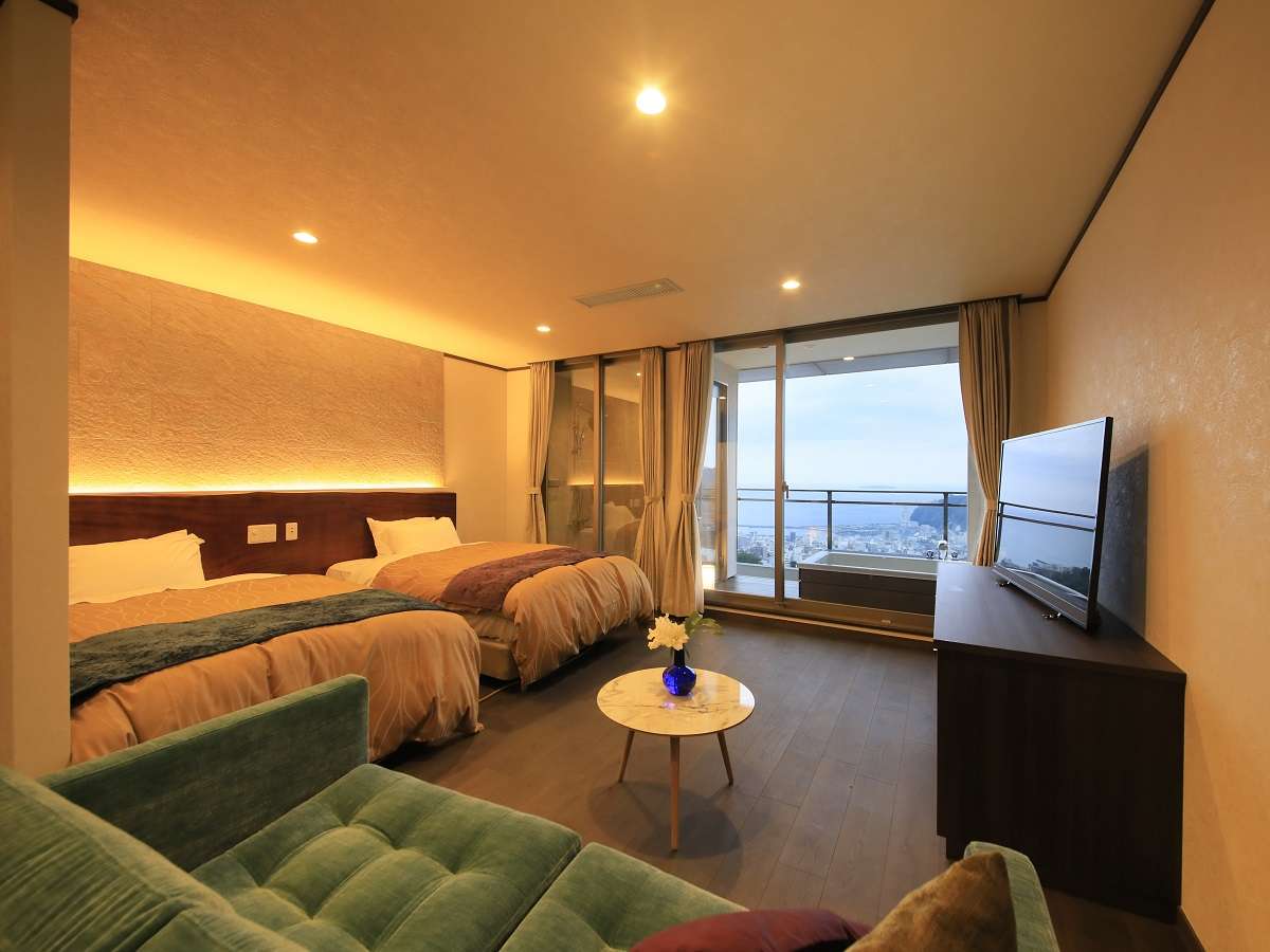 Premium guest room at Atami Fuga with twin beds and a private balcony bath overlooking the Atami sea at dusk