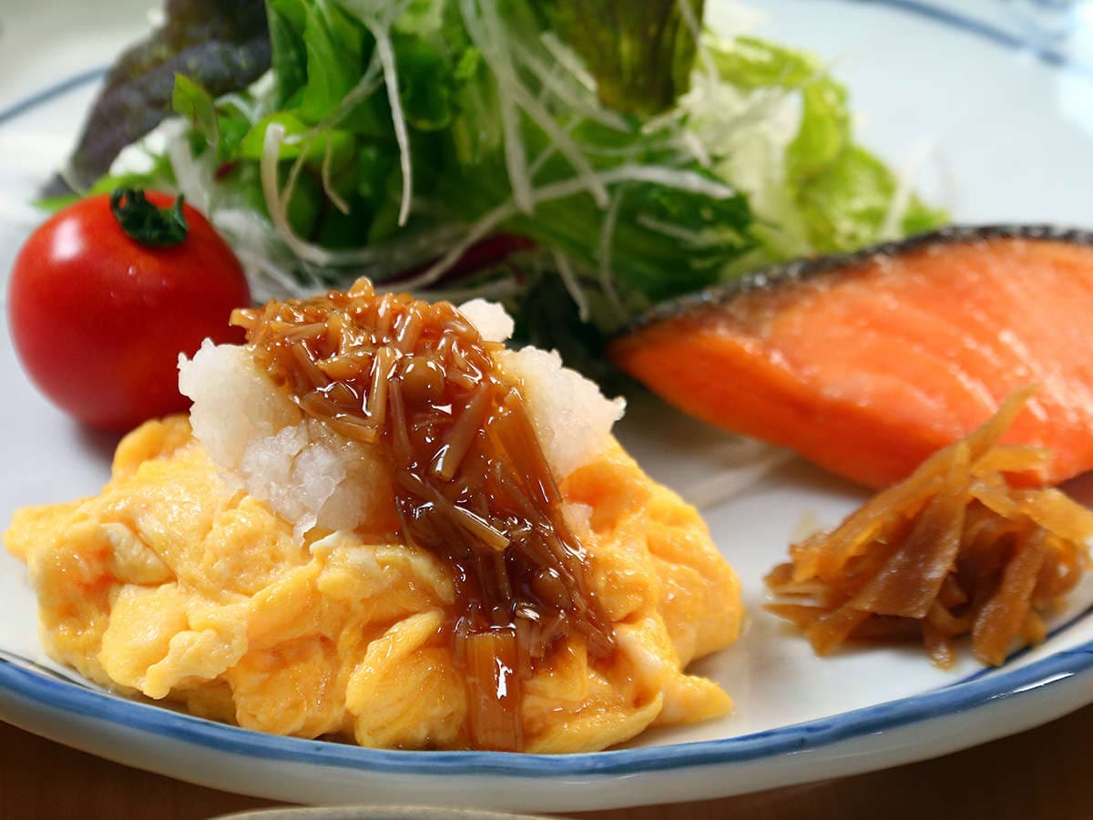 Japanese breakfast plate at Oomukou Ryokan with grilled salmon, fluffy scrambled egg, grated radish and salad