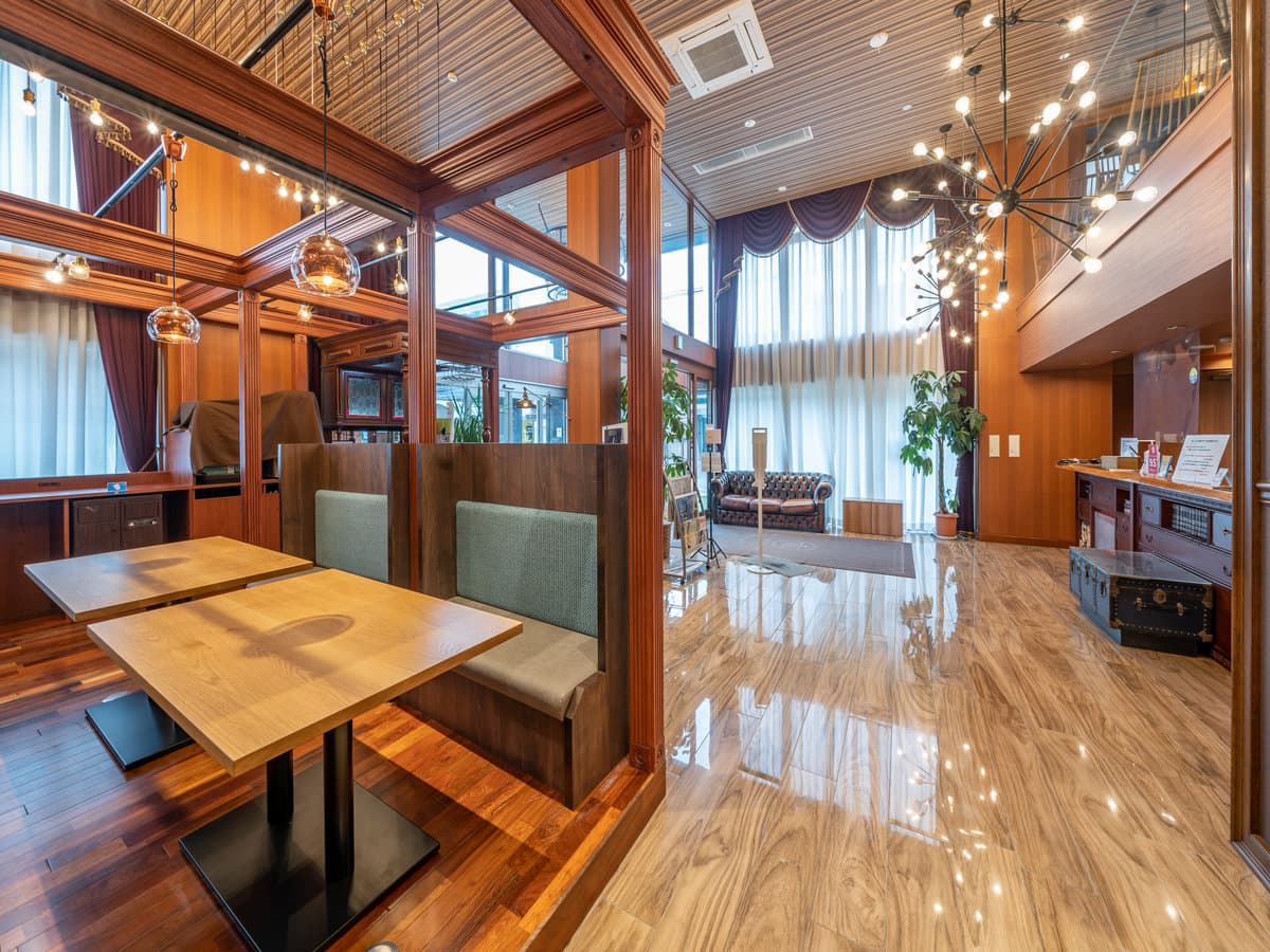 Lounge and cafe seating area at Wat Hotel Hida Takayama with wooden booths and a high atrium ceiling