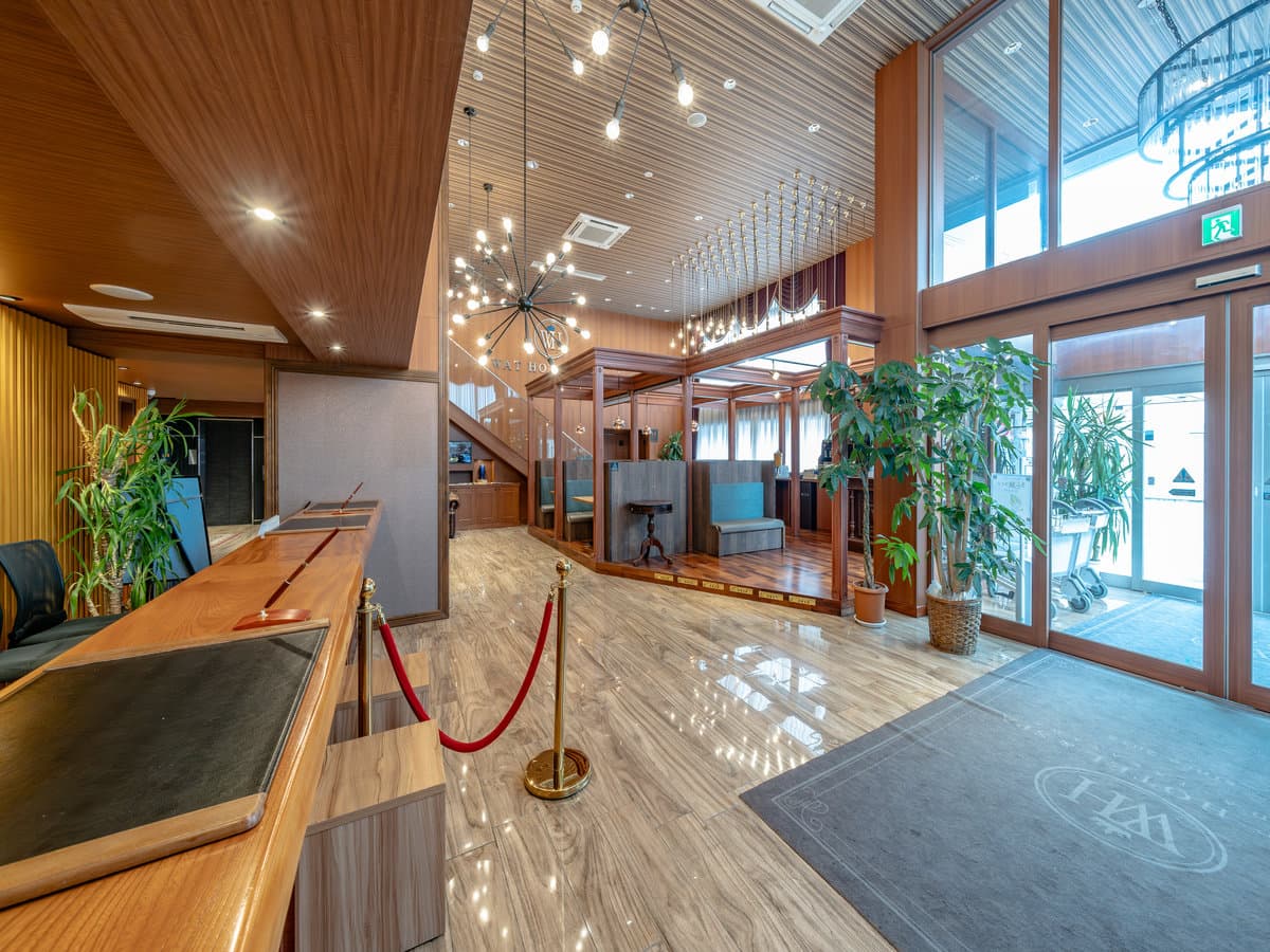 Bright wood-toned lobby and reception of Wat Hotel & Spa Hida Takayama with a chandelier and polished floor