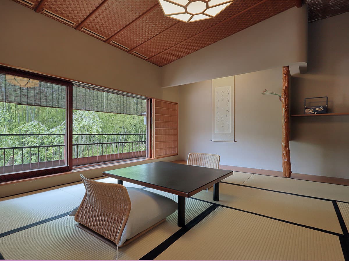 Tatami guest room with low table, hanging scroll alcove and a wide bamboo grove view at Yagyu no Sho, Shuzenji Onsen, Izu