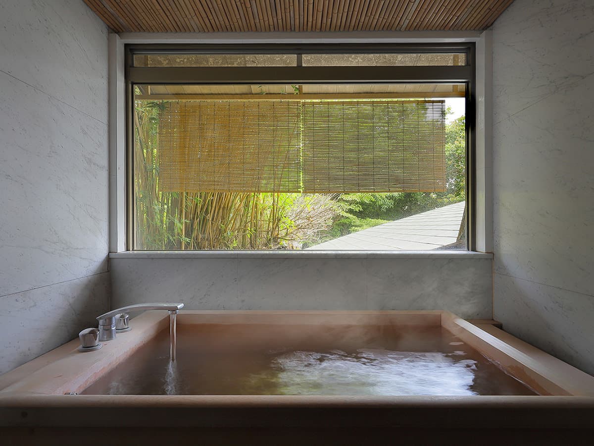 Private hinoki cypress soaking bath with steaming water overlooking a bamboo garden at Yagyu no Sho, Shuzenji Onsen, Izu