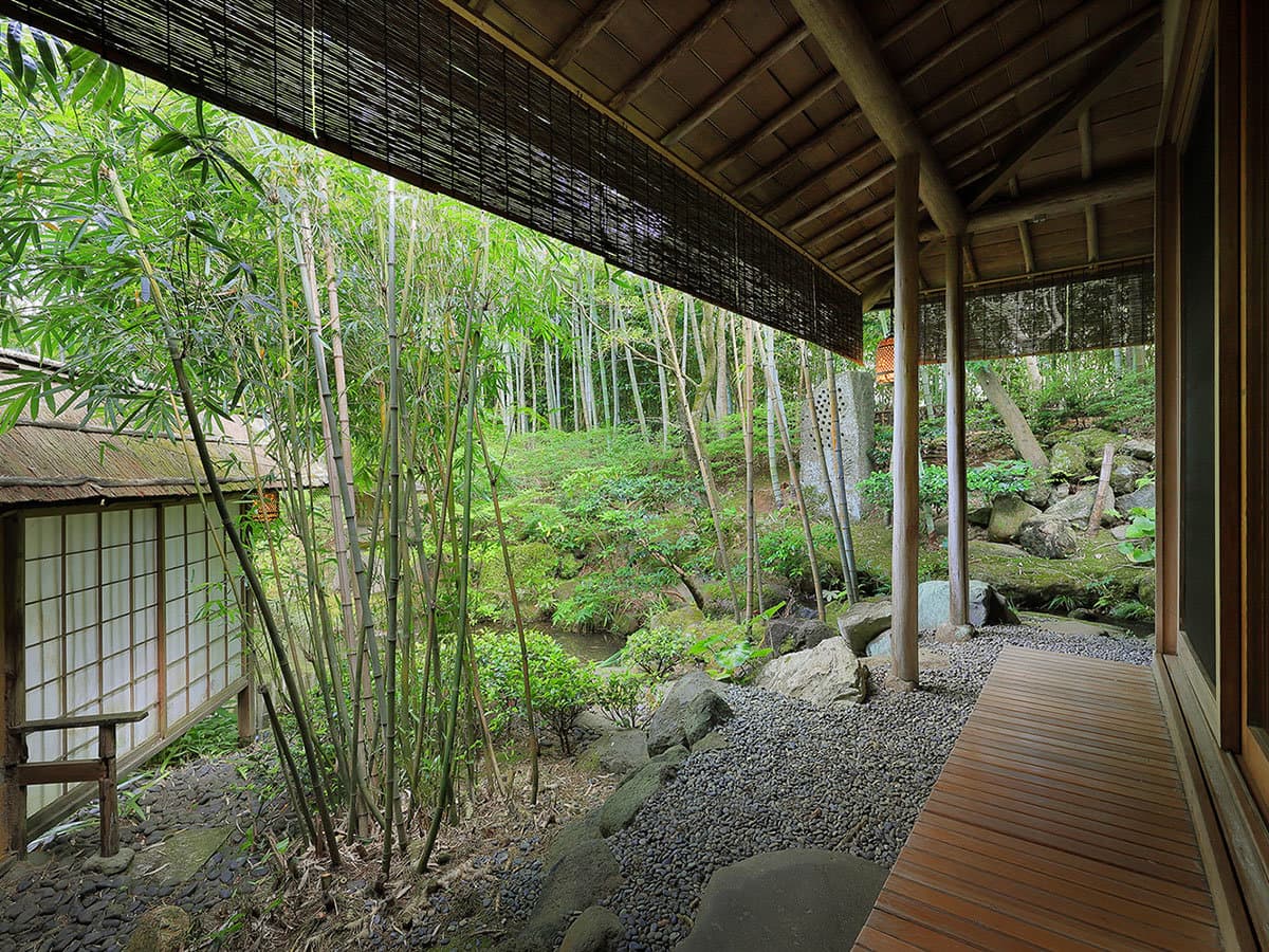 Wooden engawa veranda overlooking a lush bamboo and moss garden with a stone path at Yagyu no Sho, Shuzenji Onsen, Izu