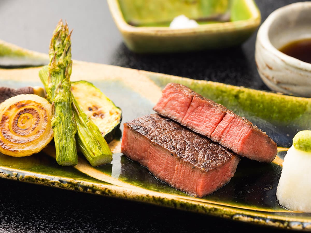 Kaiseki course of seared wagyu beef with grilled vegetables on a green ceramic plate at Yagyu no Sho, Shuzenji Onsen, Izu