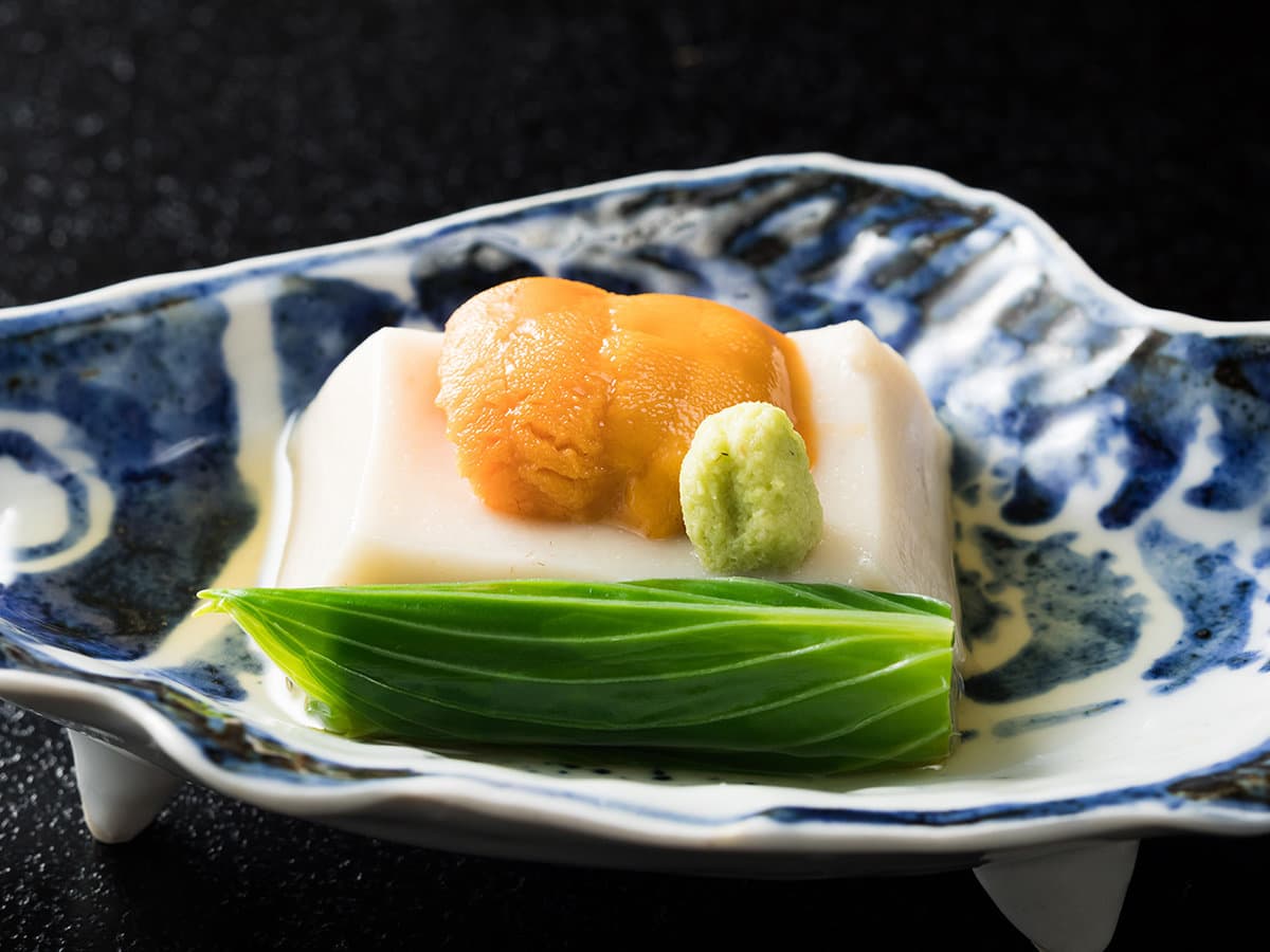 Kaiseki appetizer of chilled tofu topped with sea urchin and wasabi on a blue-and-white dish at Yagyu no Sho, Izu
