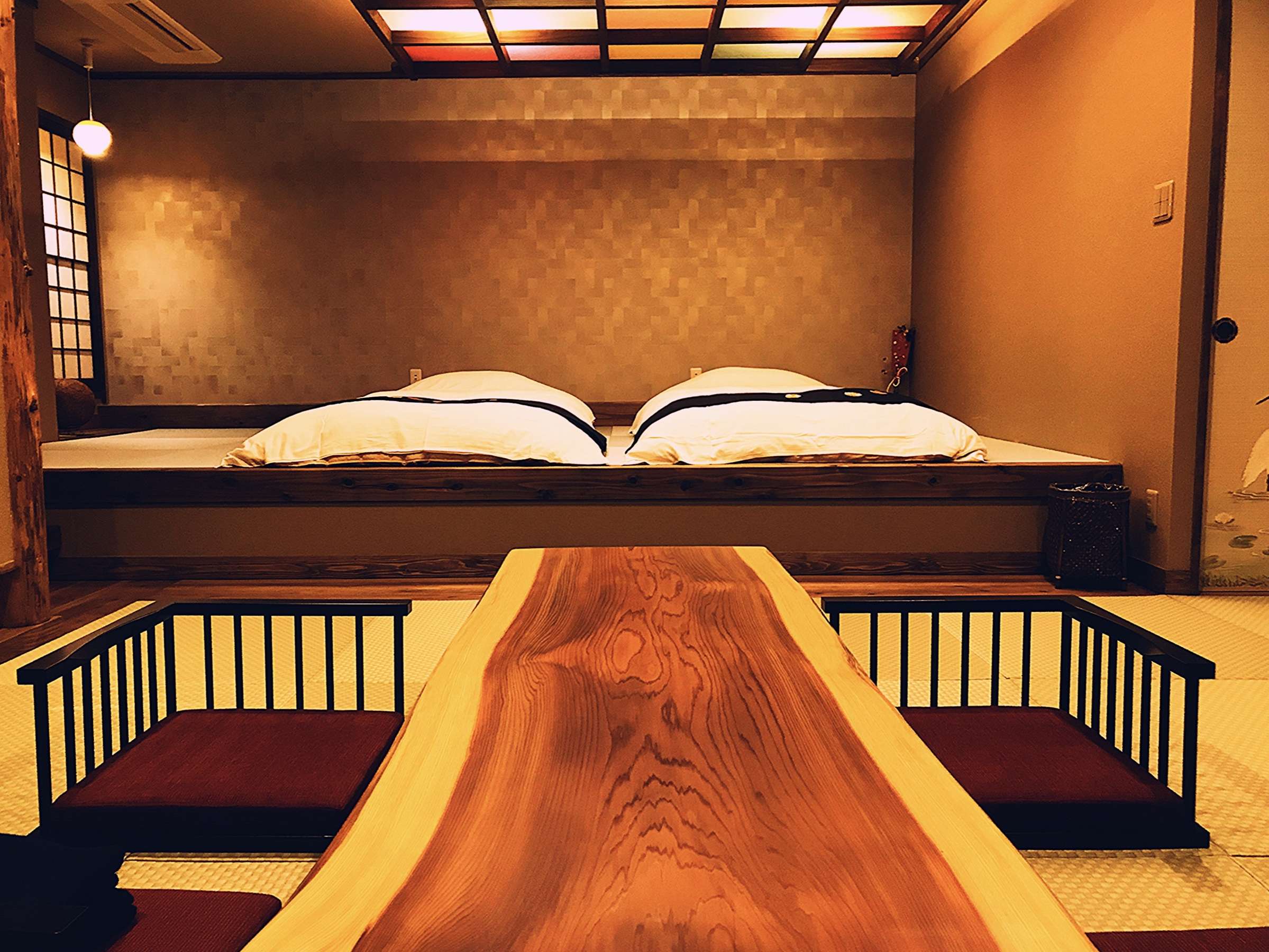 Tatami guest room at Yado Taniya with futons laid out and a thick natural-wood low table