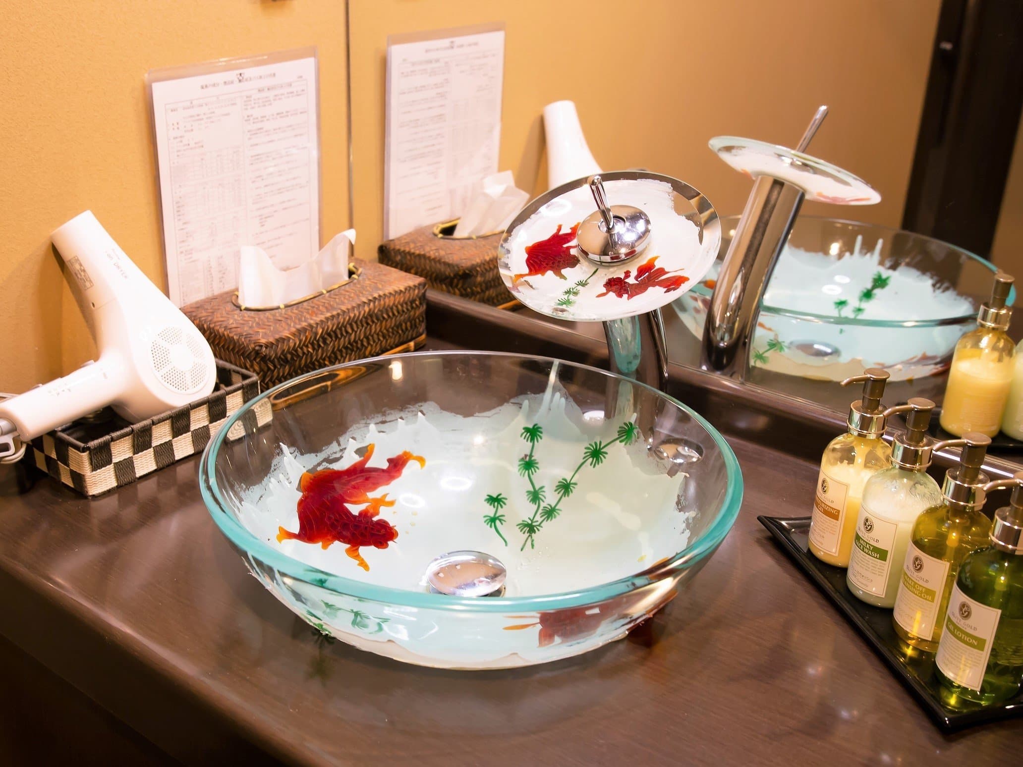 Guest room vanity at Yado Taniya with a hand-painted glass goldfish washbasin and rows of amenities