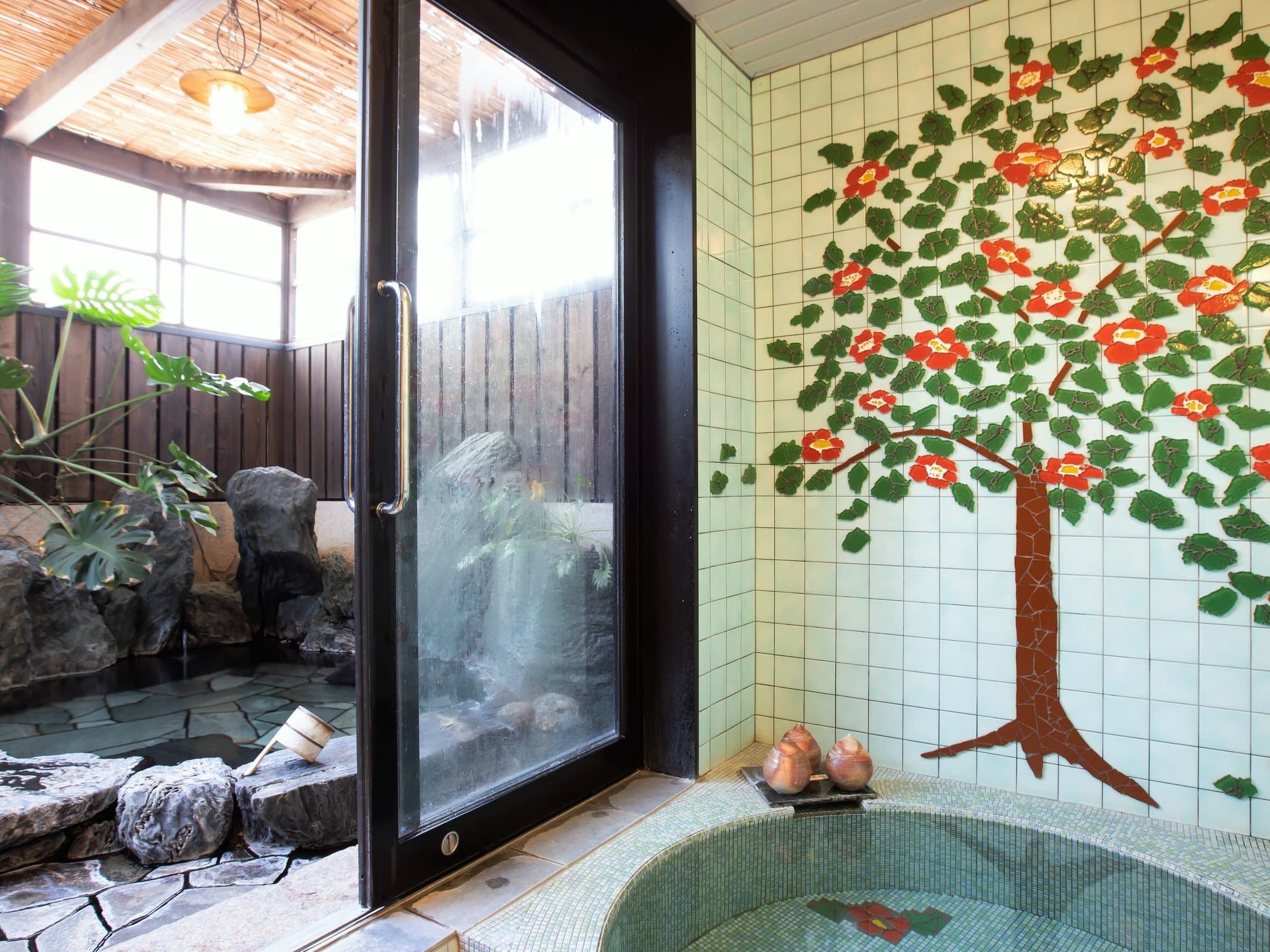 Indoor onsen bath at Yado Taniya with a camellia tile mural and a window opening onto the garden rotenburo