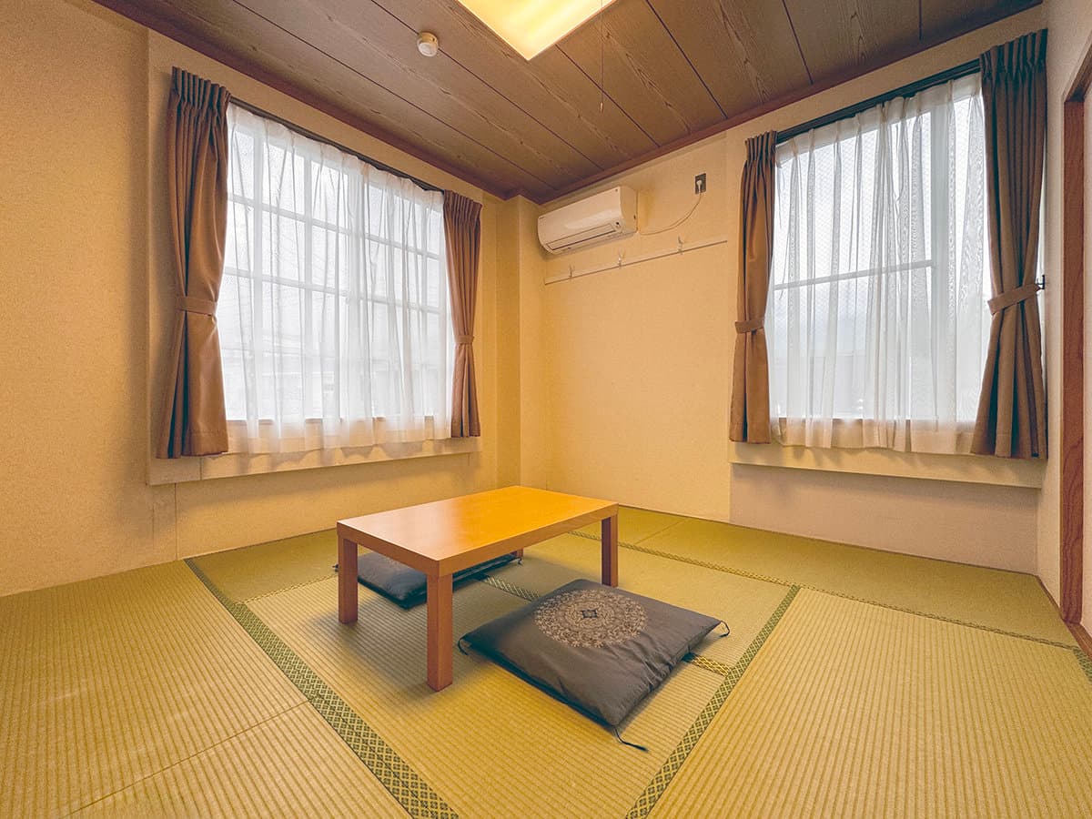 Bright Japanese-style tatami guest room with low table and cushions at Hotel Cerulean Alpen, Hakuba