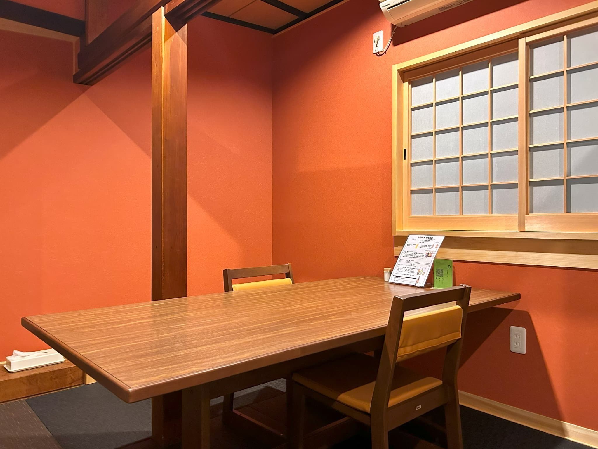 Yamatoya Ryokan Kinosaki Onsen private dining room with warm orange walls and wooden table