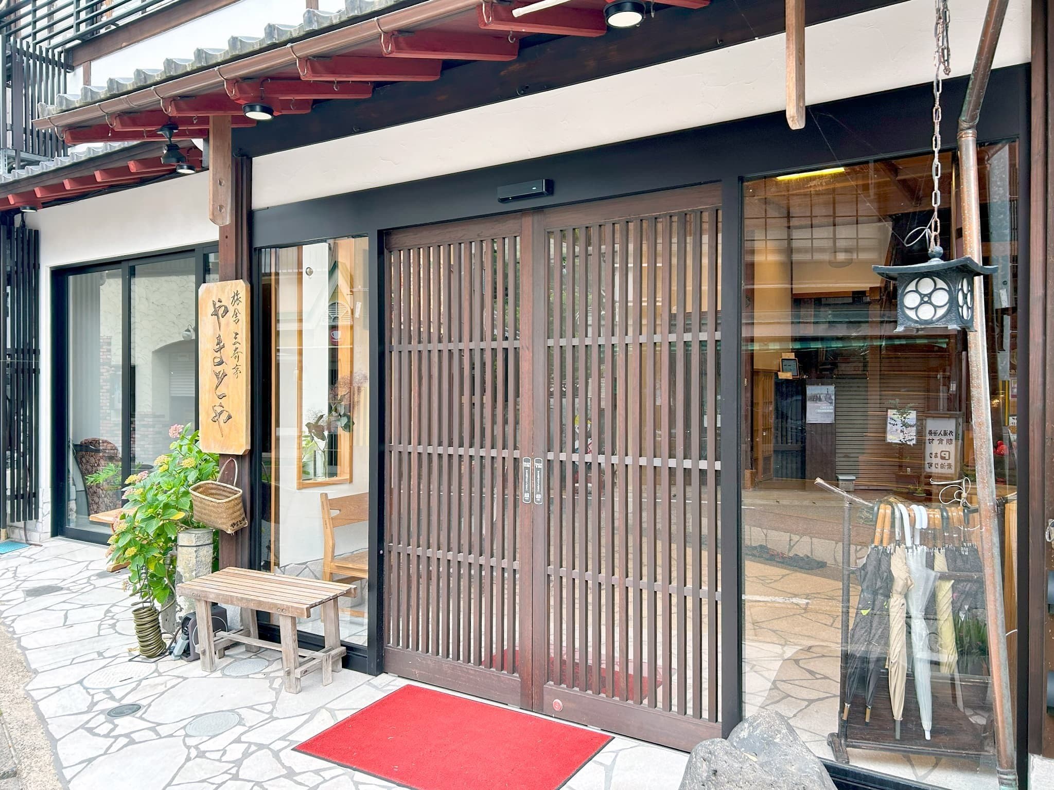 Yamatoya Ryokan Kinosaki Onsen wooden lattice entrance doorway with red welcome carpet