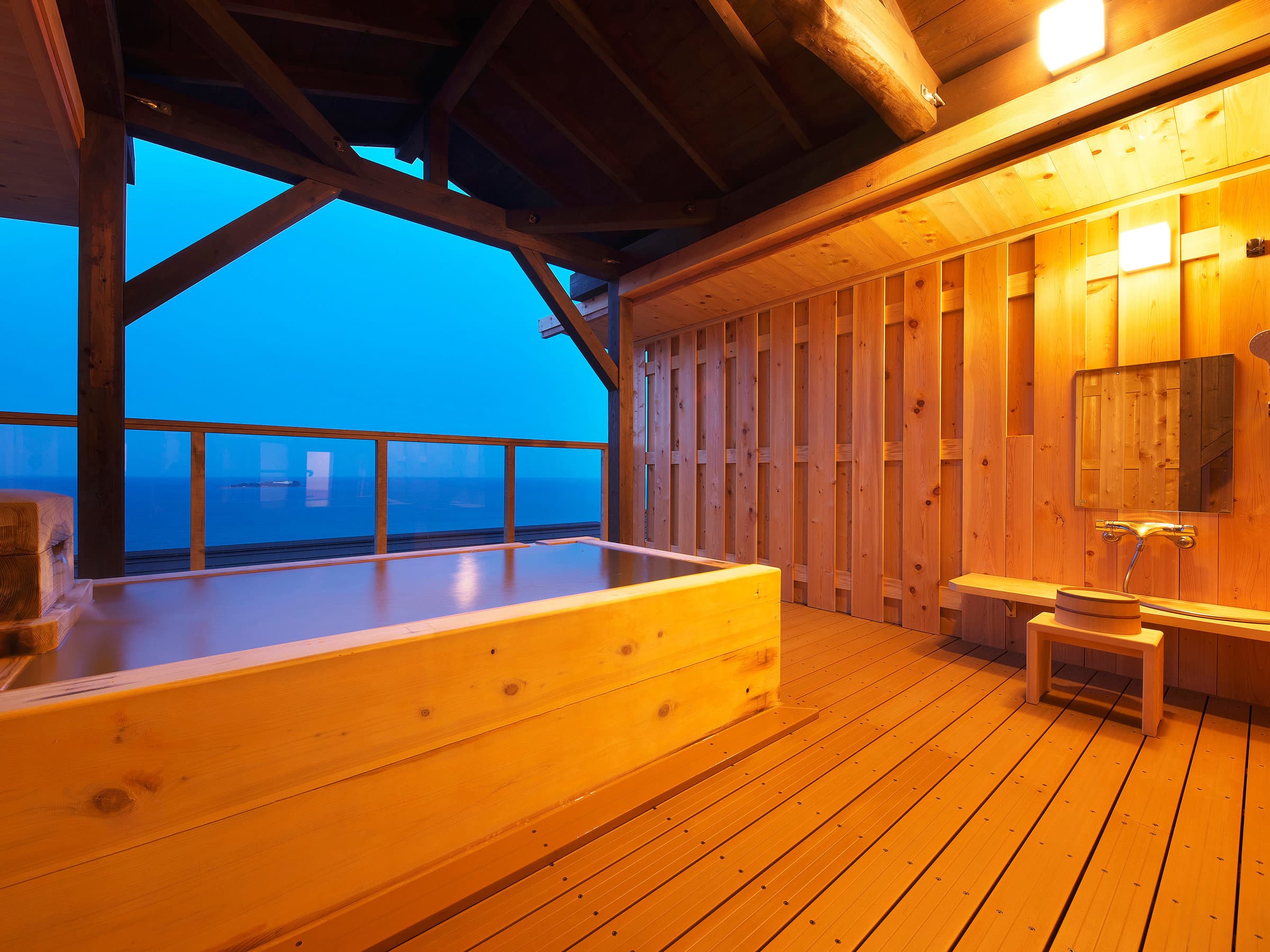 Private wooden hinoki onsen bath with sea view at dusk at Chikurinan Mizuno, Atami
