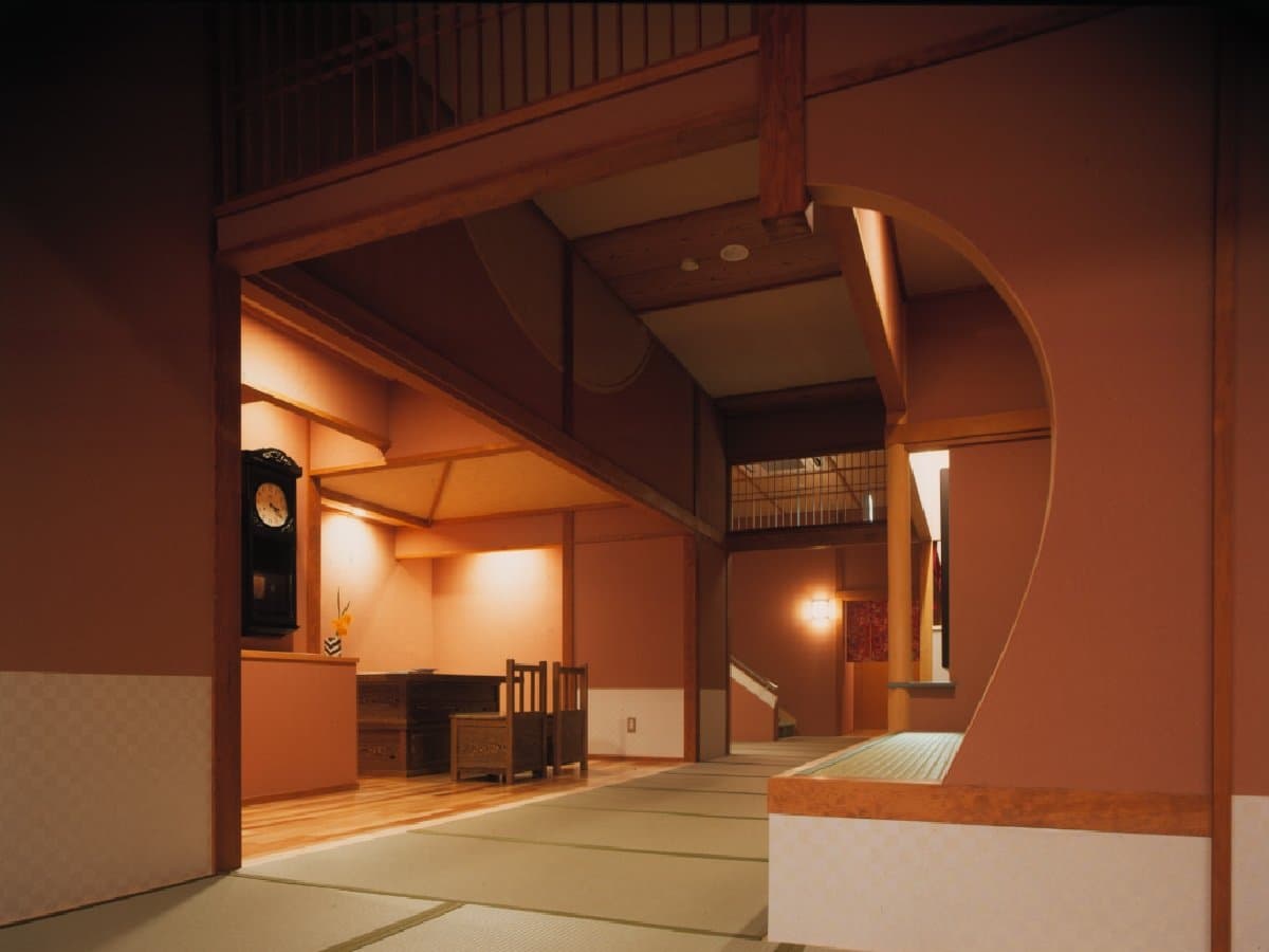 Interior tatami corridor and lobby space with antique pendulum clock and wooden beams at Noshu Iroha