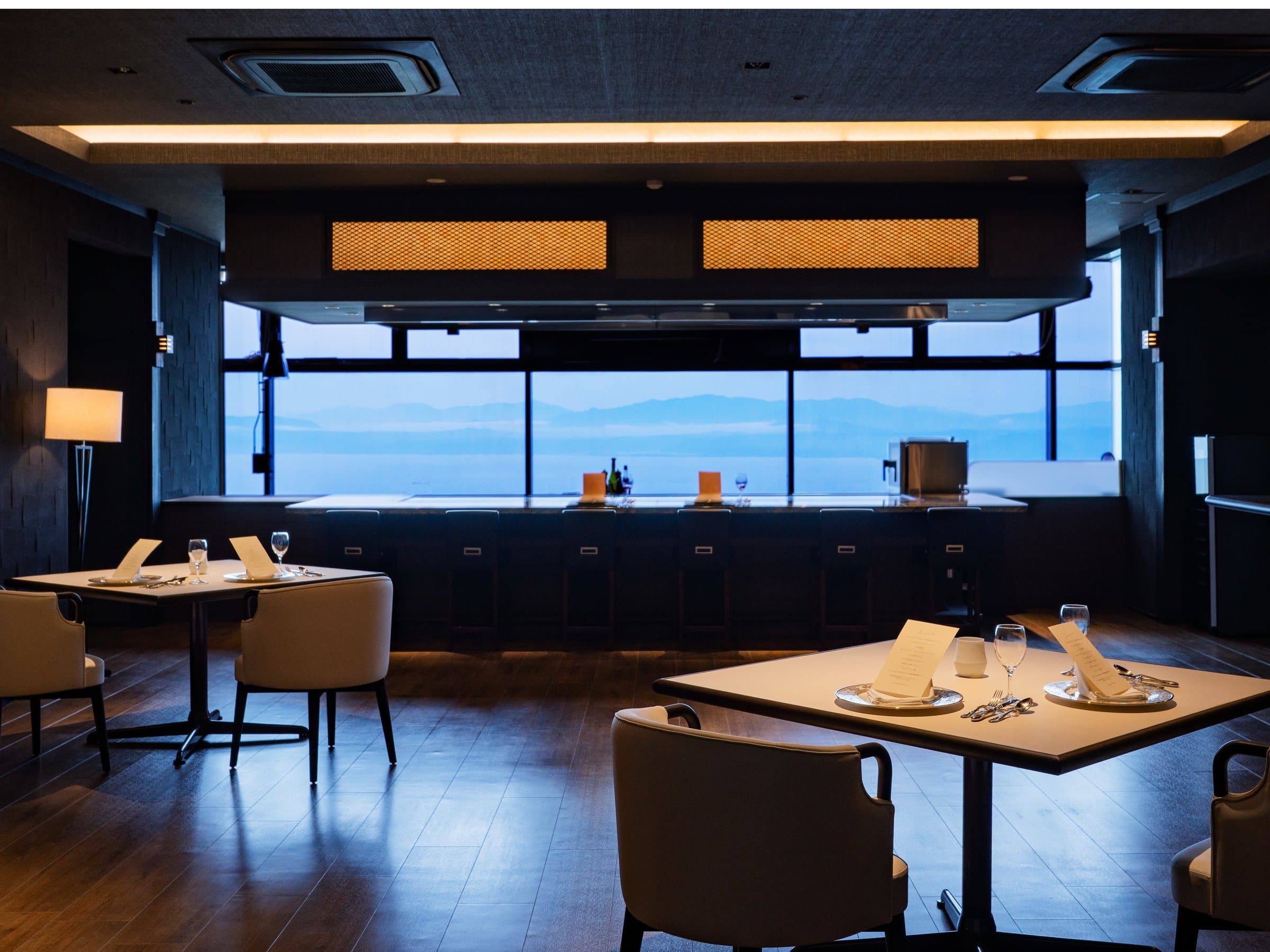 Teppanyaki dining room with counter seating and tables facing the Kagoshima Bay panorama at Bettei Amafuru Oka