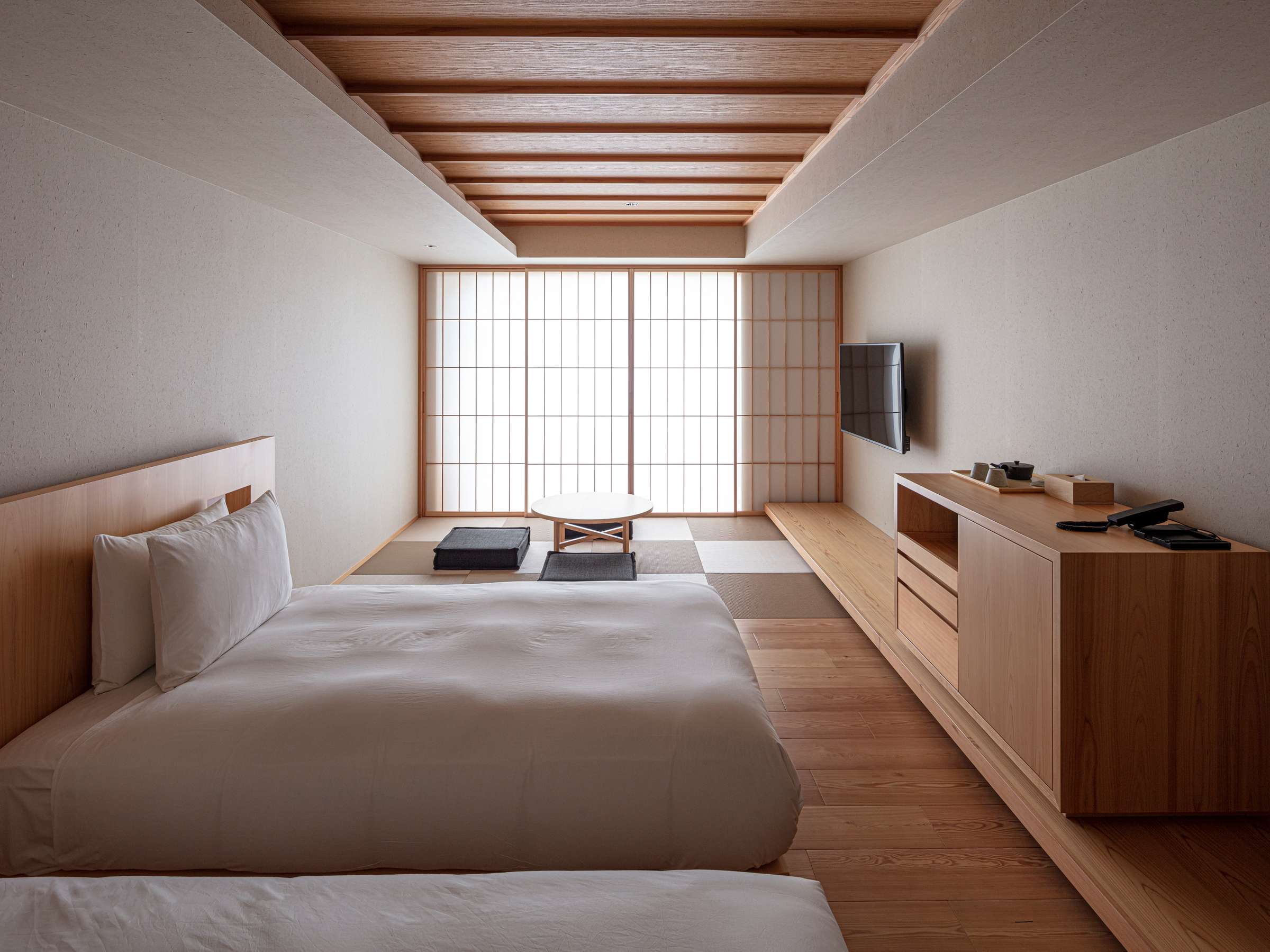 Minimalist twin guest room at SOKI ATAMI with low table on a tatami corner and shoji-screened window