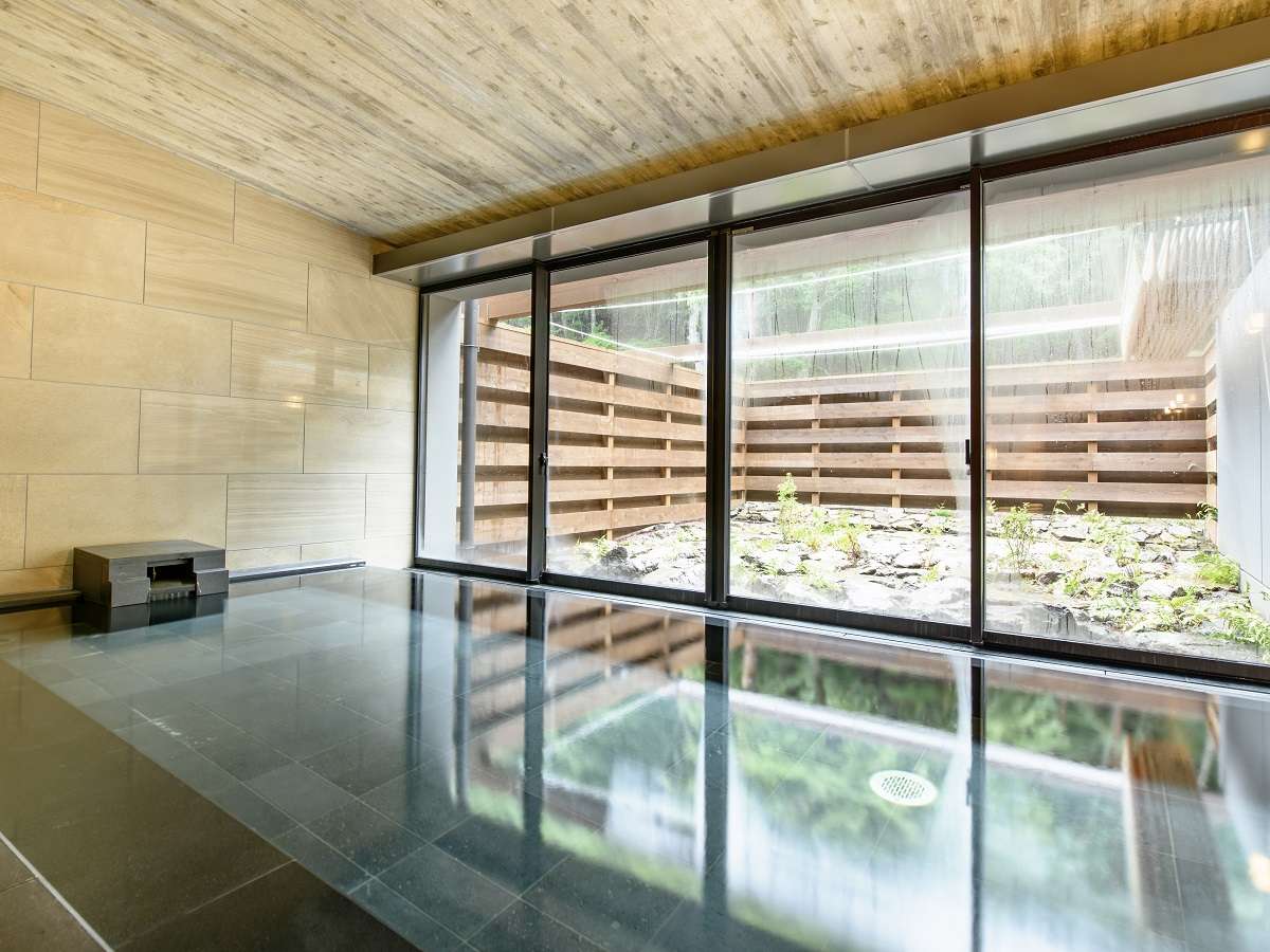 Fufu Kawaguchiko indoor bath with polished stone floor and a private rock garden beyond the glass