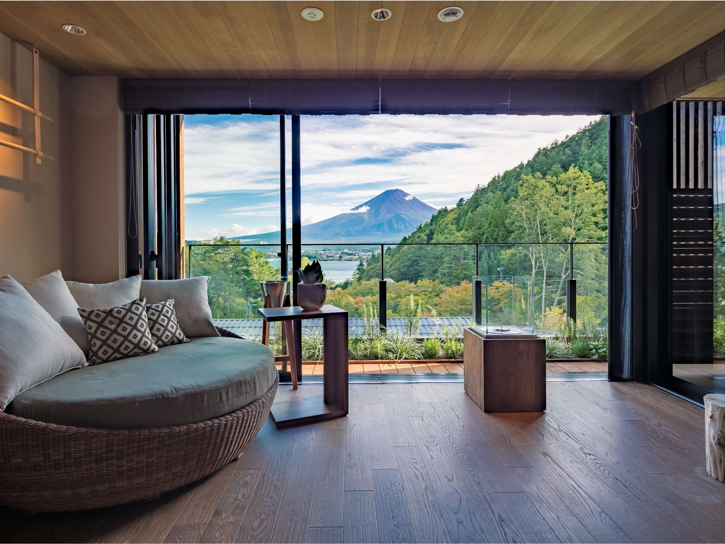 Fufu Kawaguchiko guest room with a round daybed framing Mt Fuji through floor-to-ceiling windows