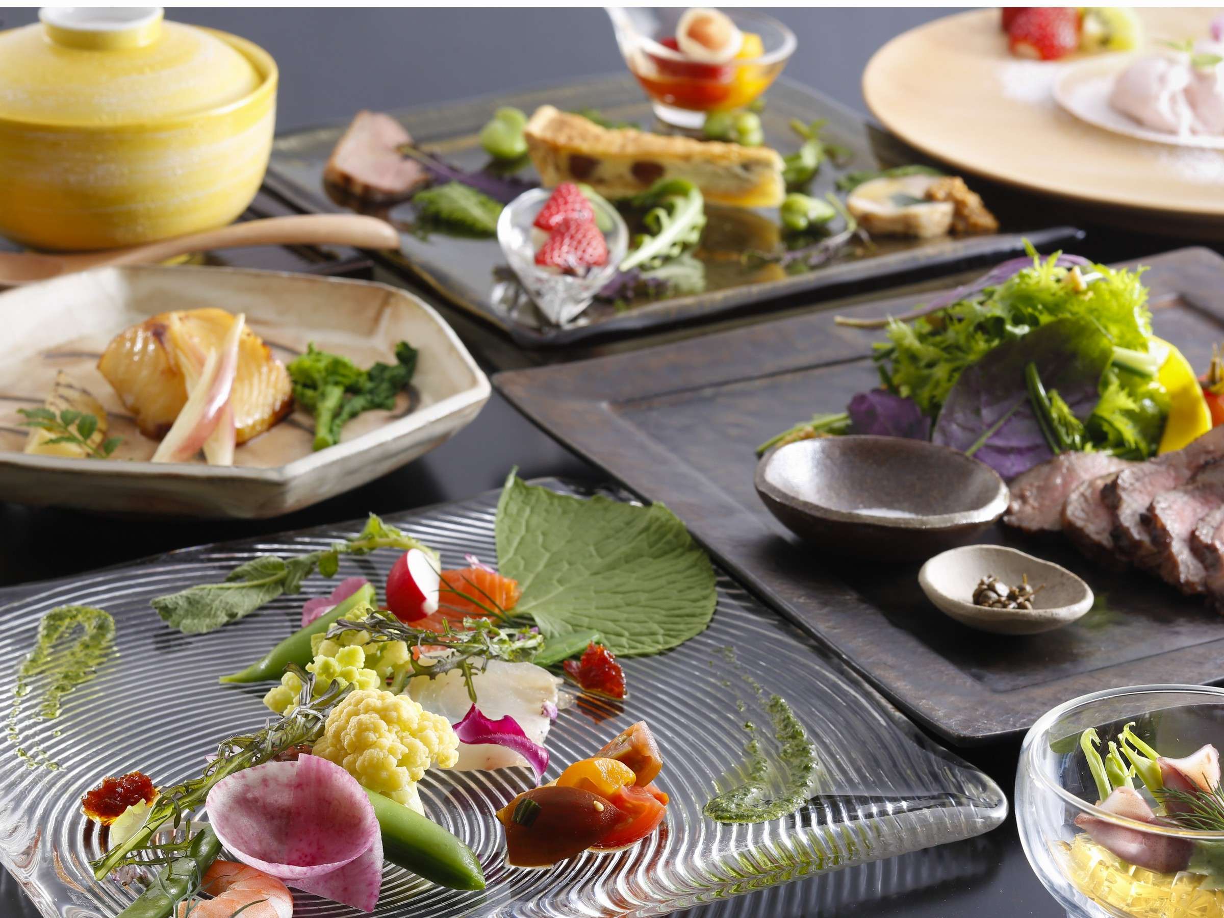 Multi-course kaiseki dinner spread on stone-grey plates with seasonal garnishes at Spa Terrace Shisui