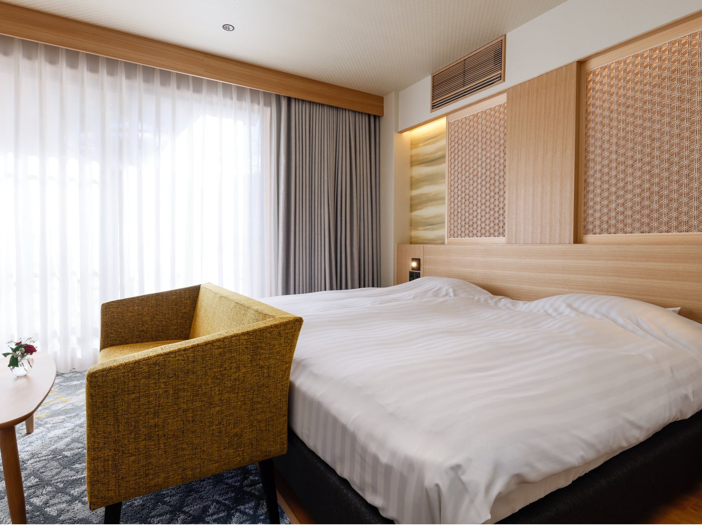 Japanese-Western twin guest room with low beds and a red accent chair at Spa Terrace Shisui