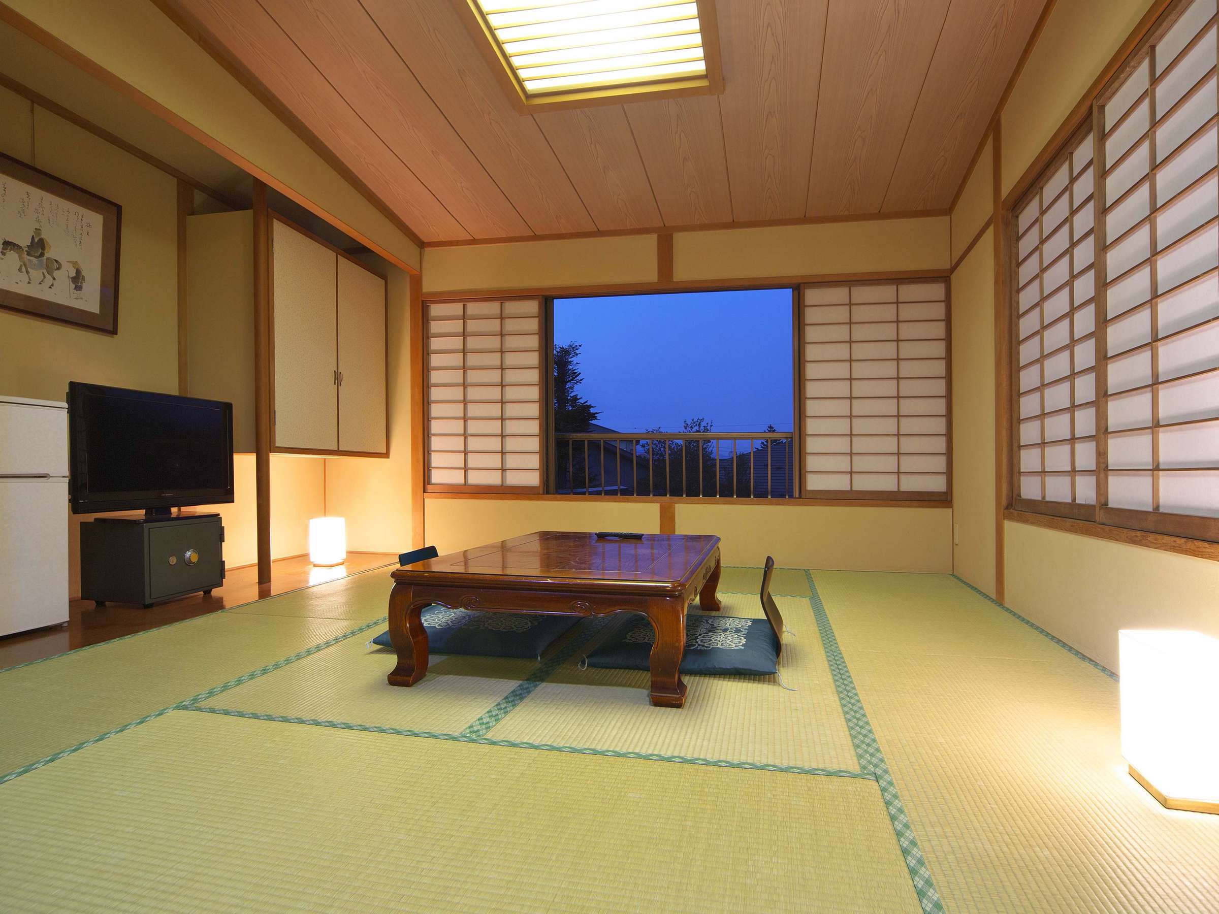 Tatami guest room with low lacquered table and shoji window glowing at dusk
