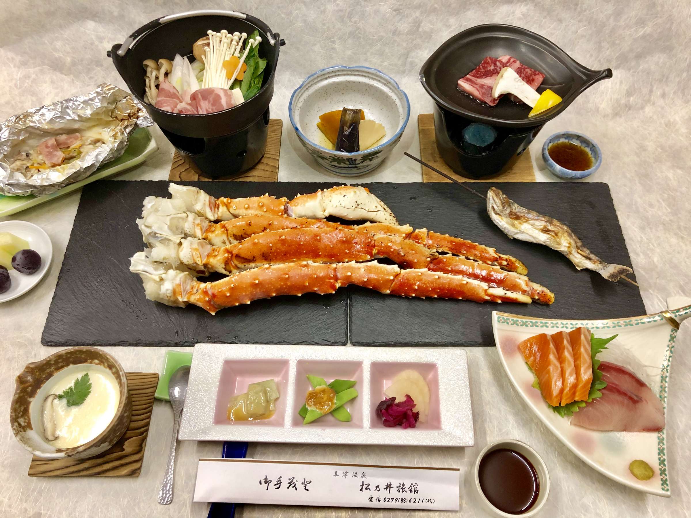 Premium kaiseki spread featuring king crab legs, sashimi and small simmered dishes
