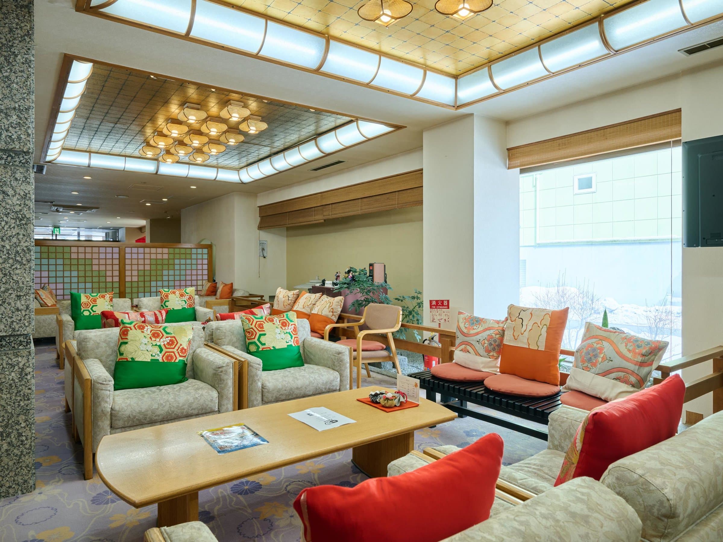 Bright lobby lounge with Japanese-style armchairs and obi-patterned cushions at Oyado Kiyomizuya