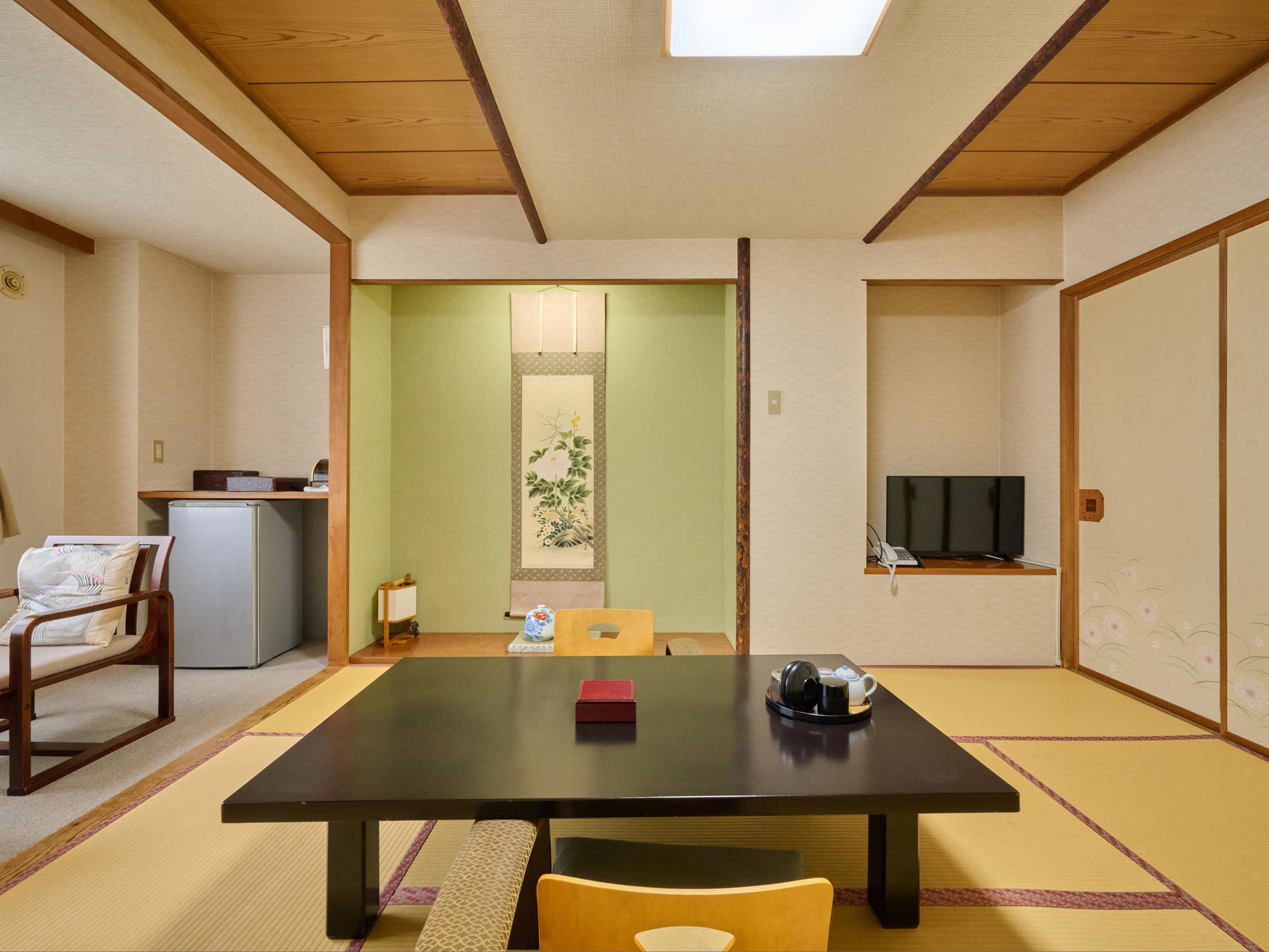 Spacious tatami guest room with low table and hanging scroll alcove at Oyado Kiyomizuya, Noboribetsu Onsen