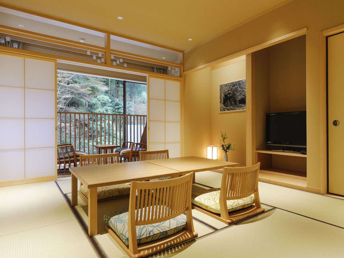 Yuraku Kinosaki tatami room with table seating and balcony view of the garden greenery