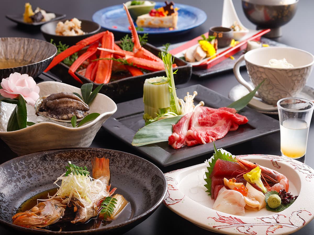 Yuraku Kinosaki kaiseki dinner spread with snow crab, sashimi and beef on a single table