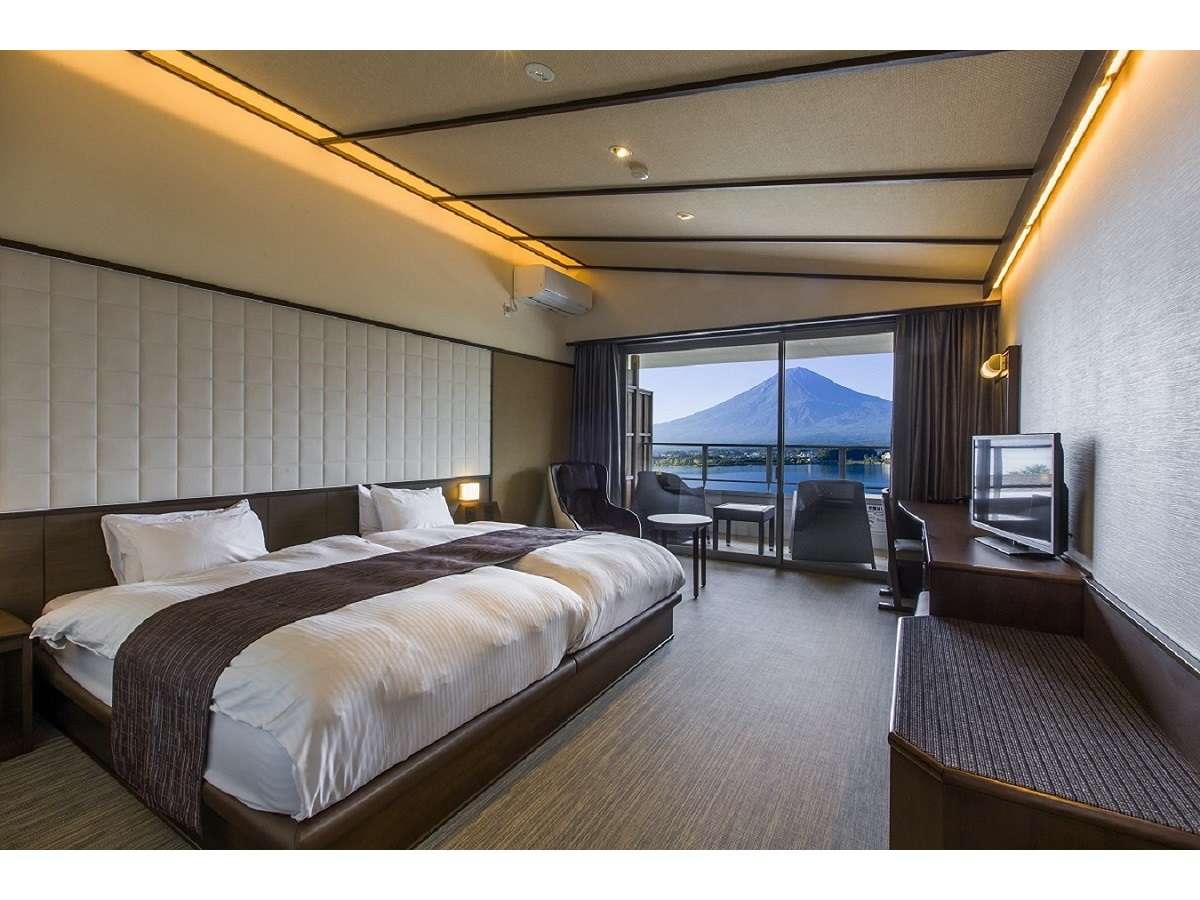 Western-style twin bedroom at Sunnide Resort opening to a balcony with a clear Mt Fuji and Lake Kawaguchiko view