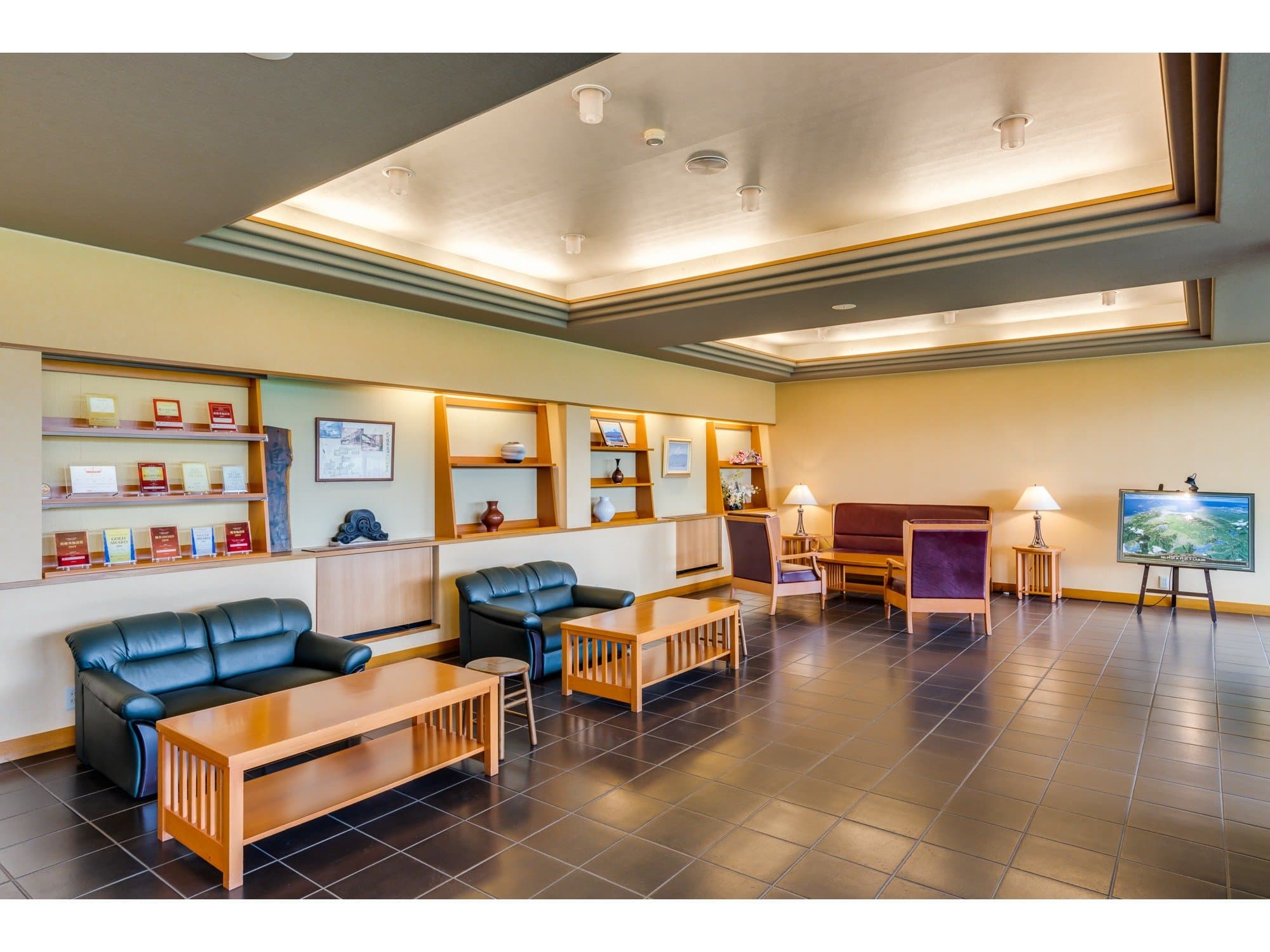 Spacious lobby lounge at Sunnide Resort with leather sofas, wooden tables and a recessed-light ceiling