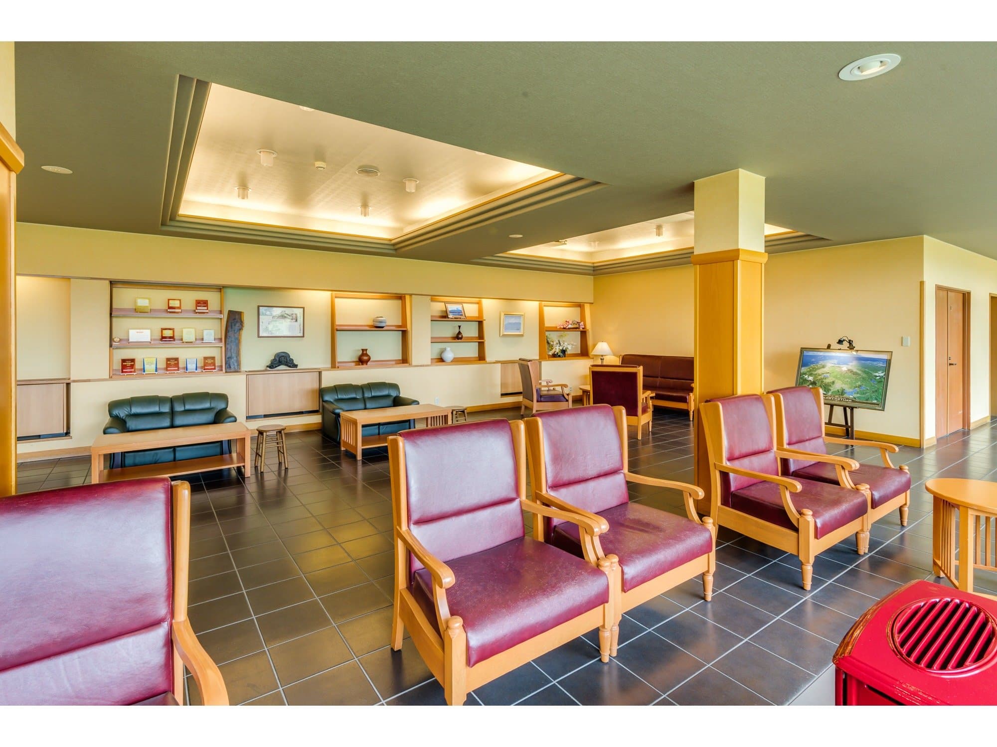 Lounge seating area at Sunnide Resort with cushioned wooden armchairs on a dark tile floor