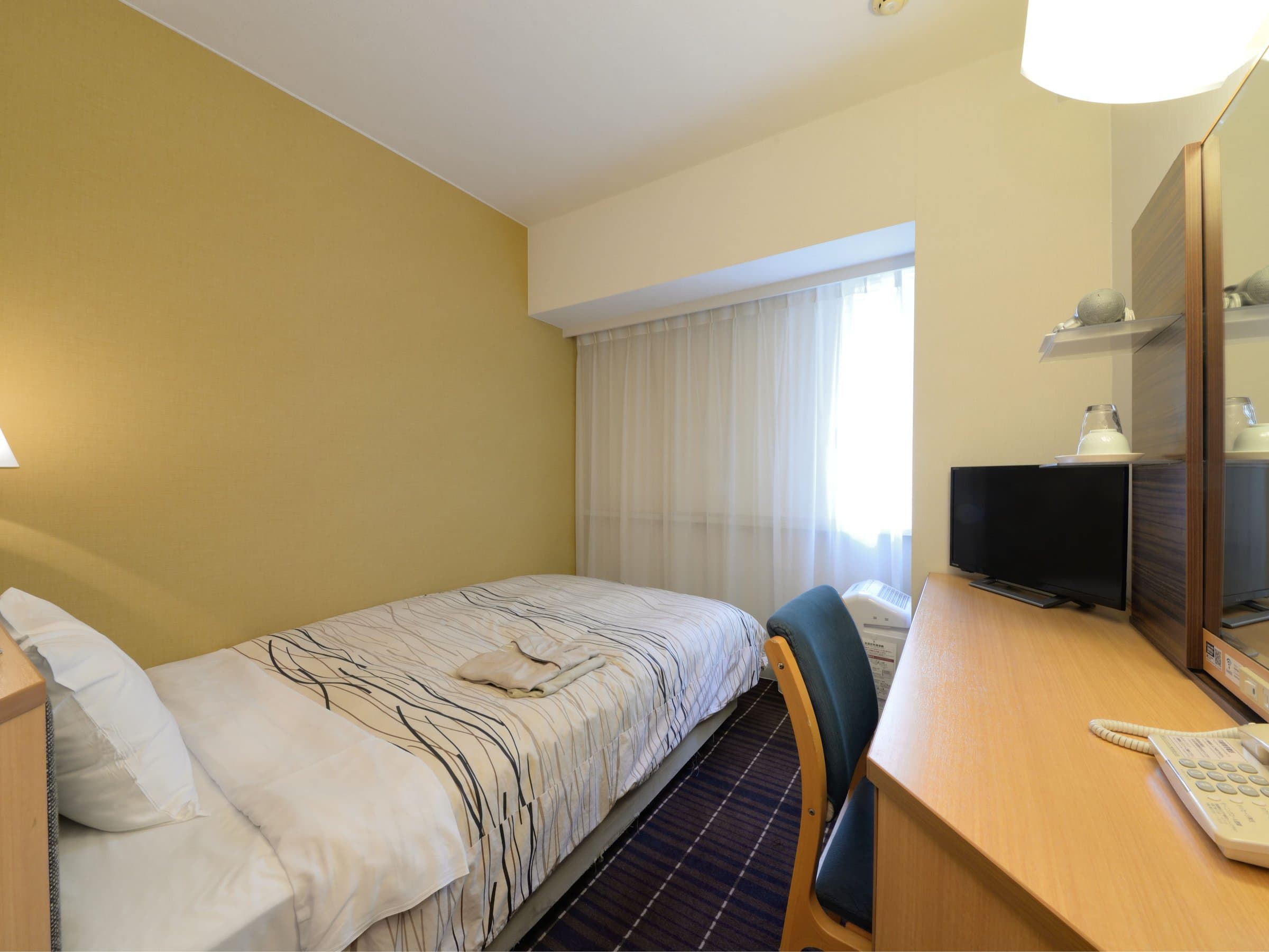 Standard single guest room with desk and TV at Kanazawa Manten Hotel Ekimae