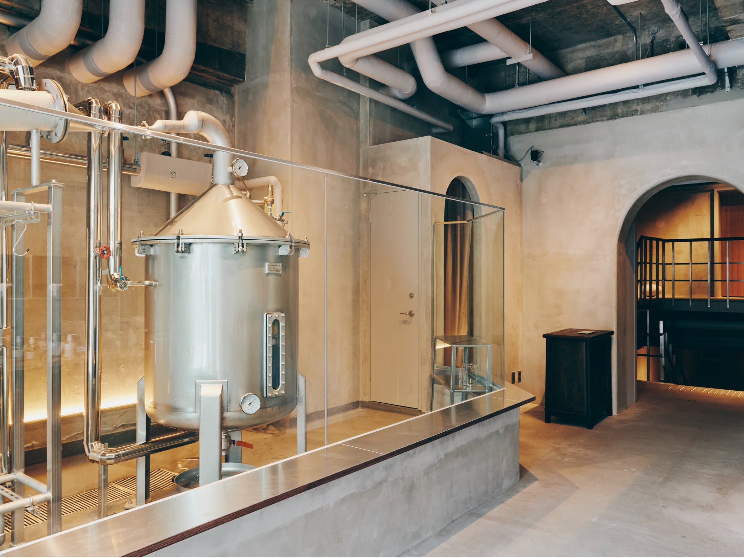 In-house craft gin distillery copper still and piping behind glass at Korinkyo Kanazawa