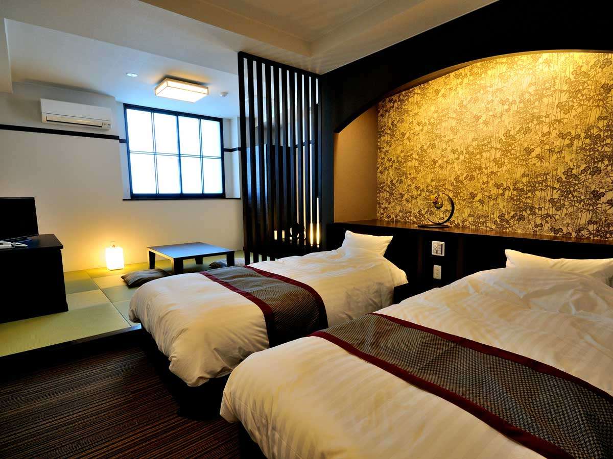Oyado Yukizumi premium room with two beds, gold floral feature wall, tatami corner with low table and shoji-lit window