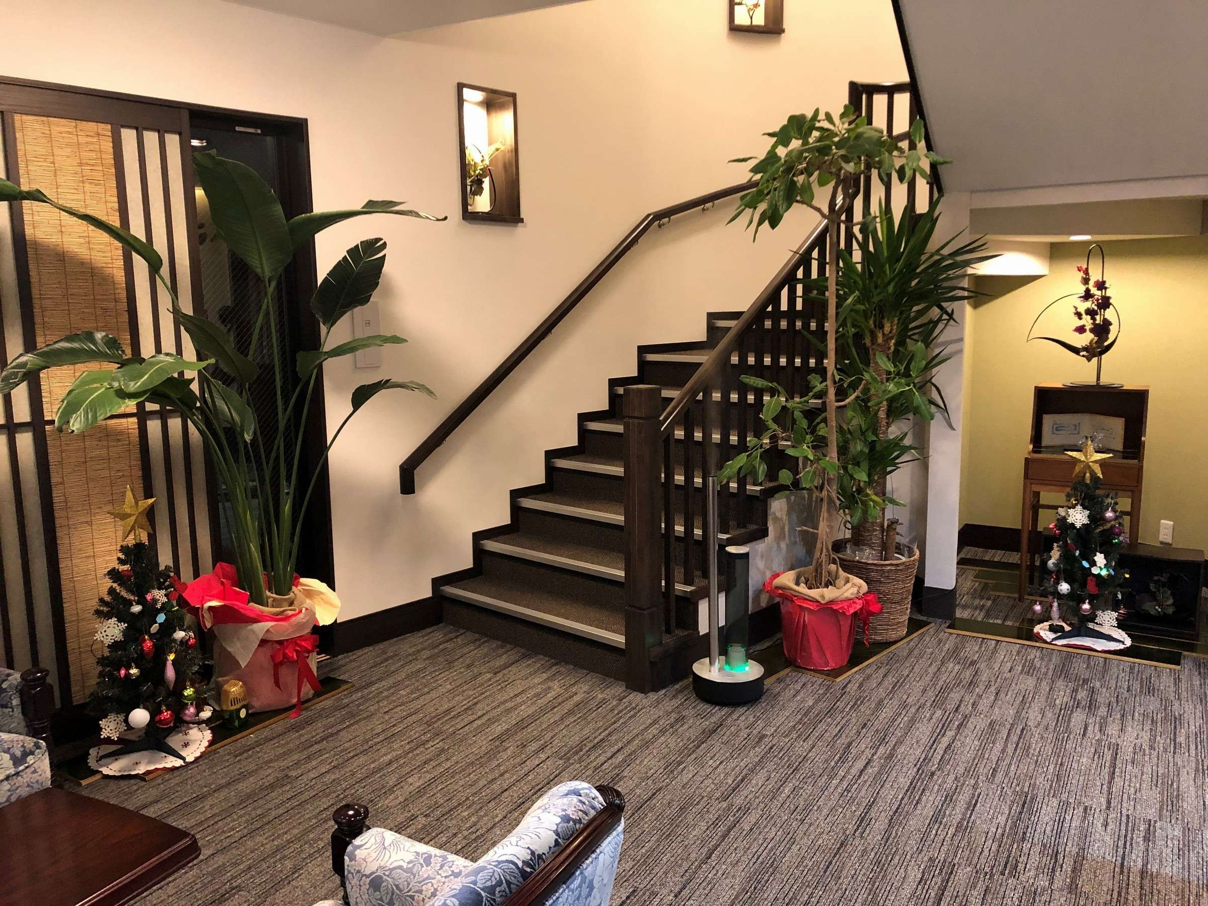 Oyado Yukizumi lobby and interior stairwell with dark wood staircase and potted greenery