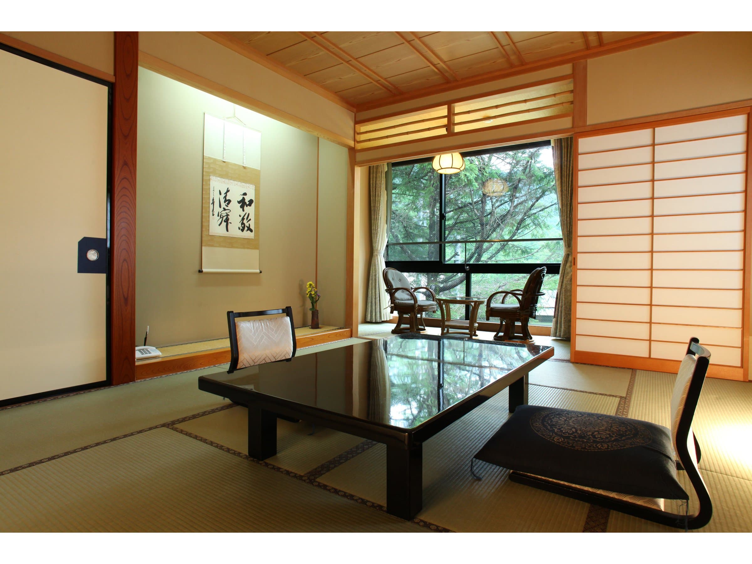 Japanese-style room with hanging scroll in the tokonoma alcove and a forest-view window at Shirafuneso Shintaku Ryokan, Shirahone Onsen