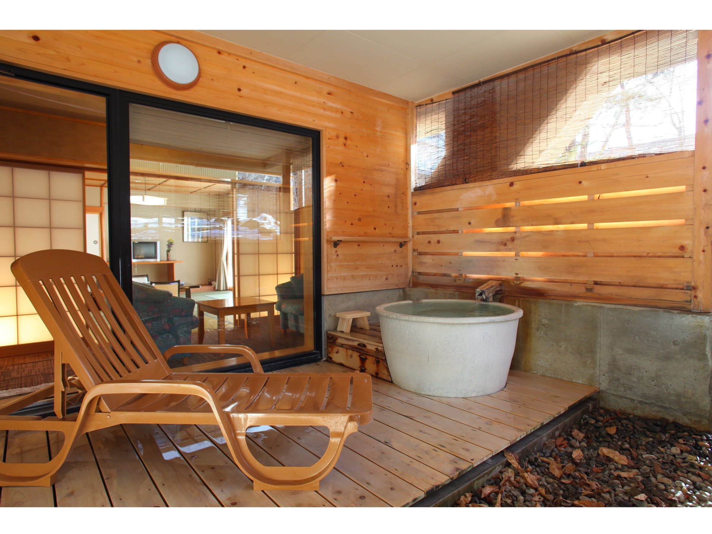 Private open-air cypress bath with wooden lounger and timber screen on a guest-room terrace at Shirafuneso Shintaku Ryokan, Shirahone Onsen