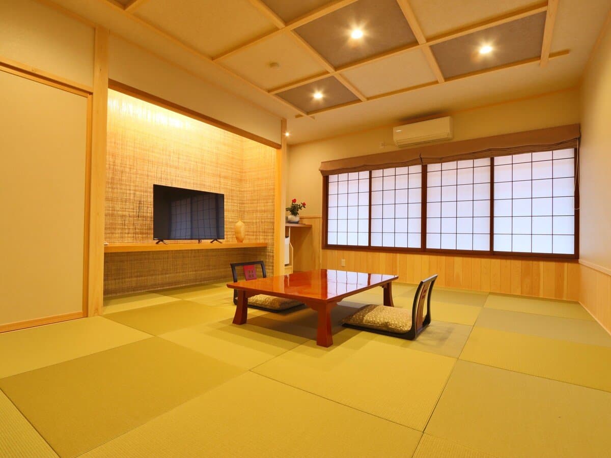 Bright Japanese-Western tatami room with shoji screens and low dining table at Ryokan Tanabe