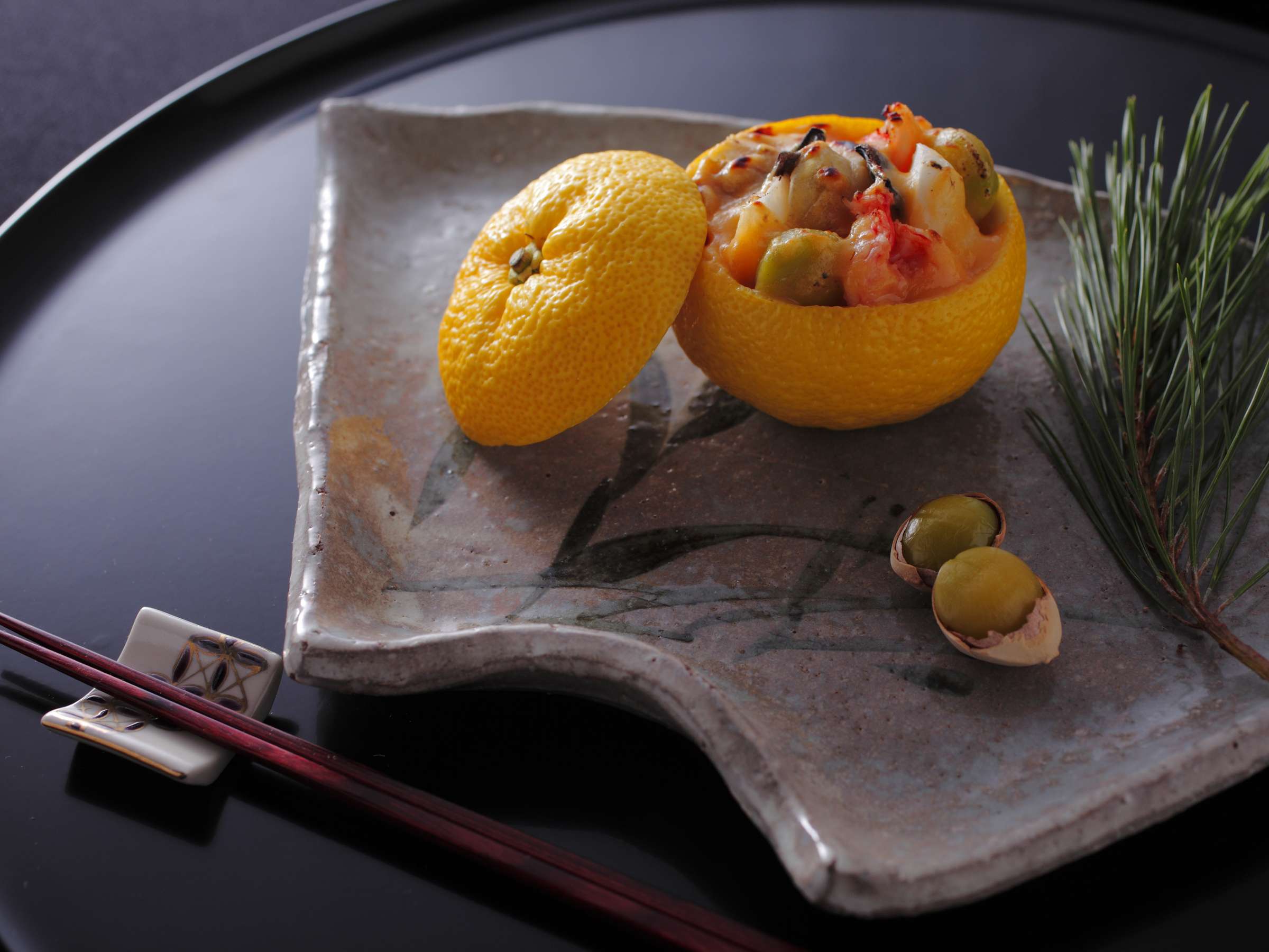 Yuzu-gama kaiseki appetizer at Hashinoya Bekkan Ransui, a hollowed yuzu citrus filled with seafood and ginkgo nuts on a rustic ceramic dish