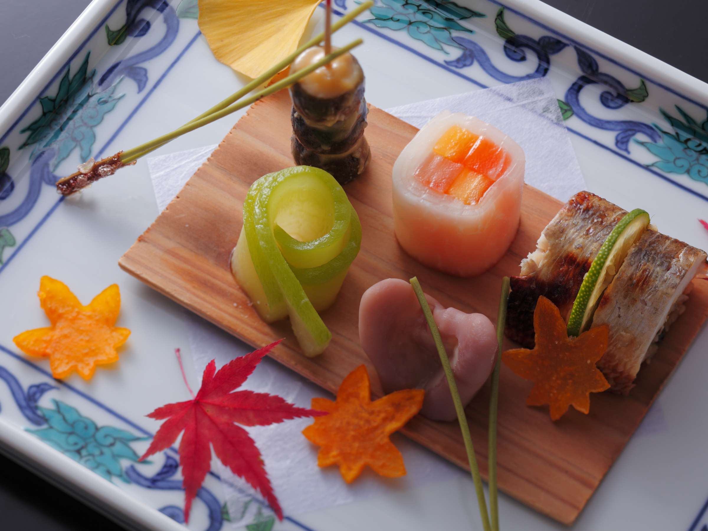 Multi-course kaiseki dinner at Hashinoya Bekkan Ransui with a simmered kinki fish course, tempura plate and a yuzu-shell appetizer arranged on dark lacquer