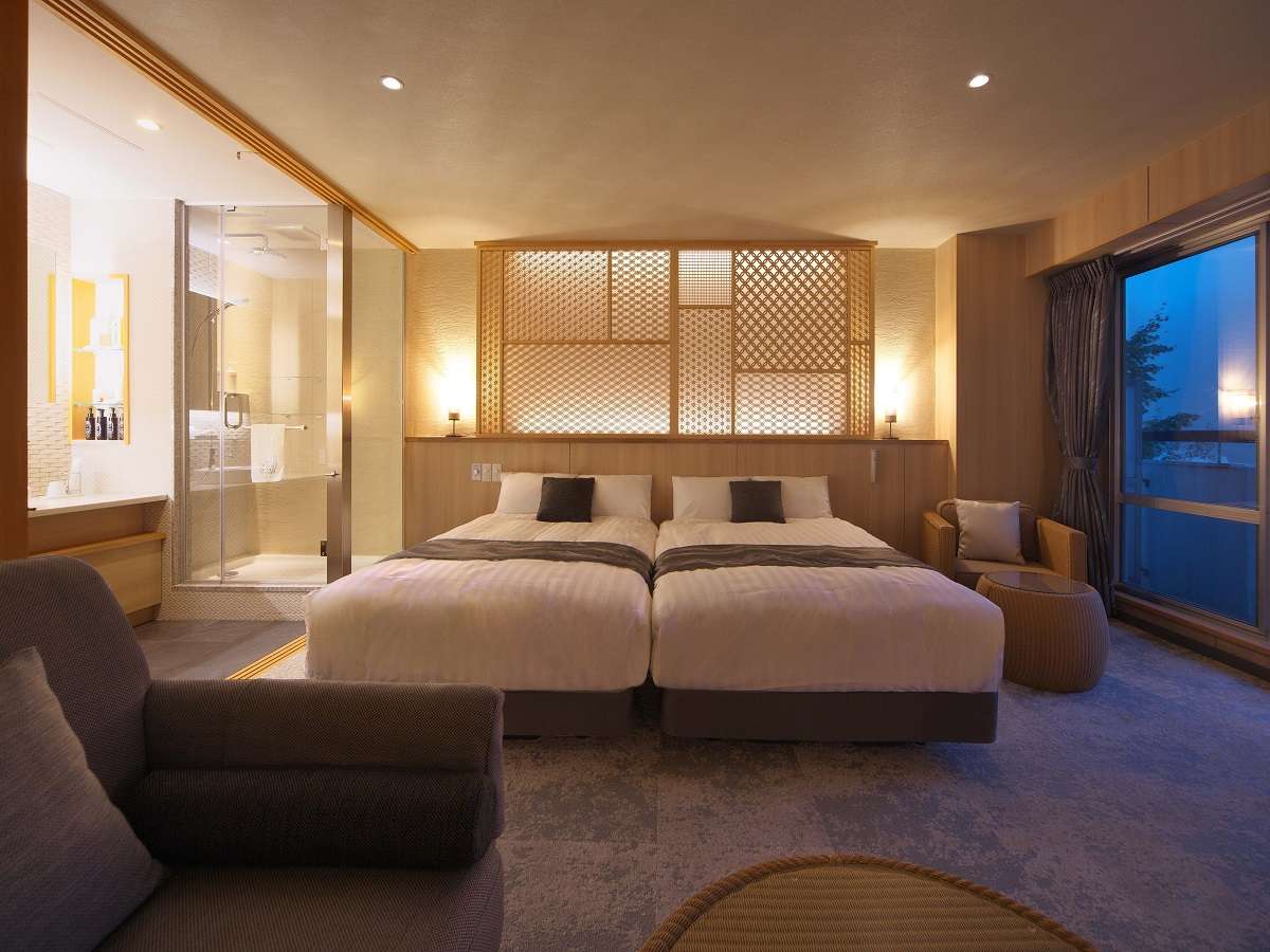 Twin-bed room with kumiko lattice headboard panel and glass-walled bathroom at Hotel Spax Kusatsu